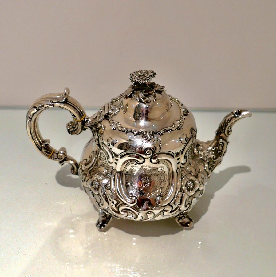 A very Ffine ‘Louis’ style silver teapot ornately decorated with floral embellishments which are then set on a matte background for decorative contrast. The domed lid is hinged and is mounted with a cast floral finial. Both cartouches have Fine