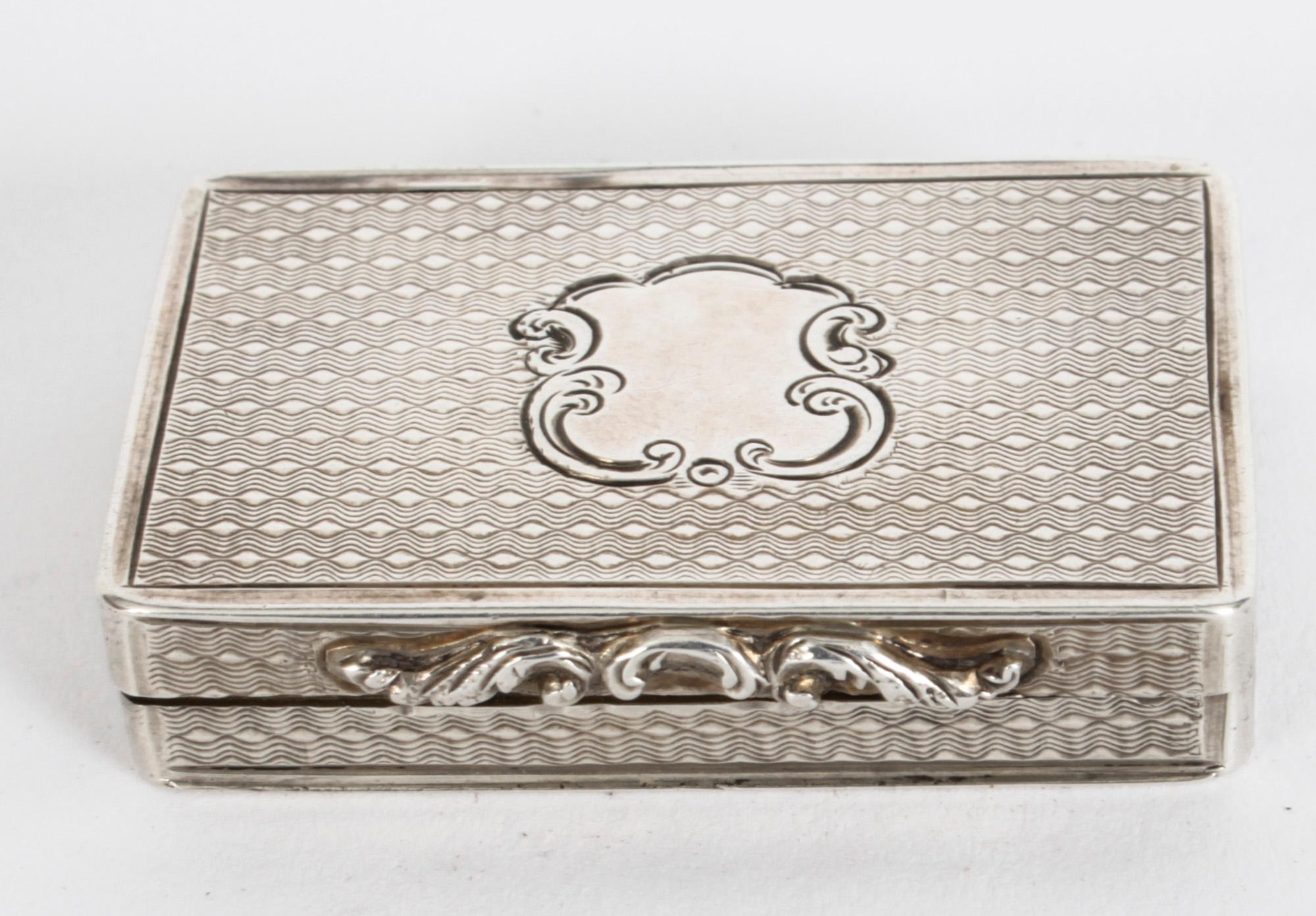 This is an exquisite antique Victorian sterling silver vinaigrette with hallmarks for Birmingham 1849 and the makers mark of the silversmith Cronin & Wheeler.
 
The vinaigrette is of rectangular form with engine turned decoration and a vacant