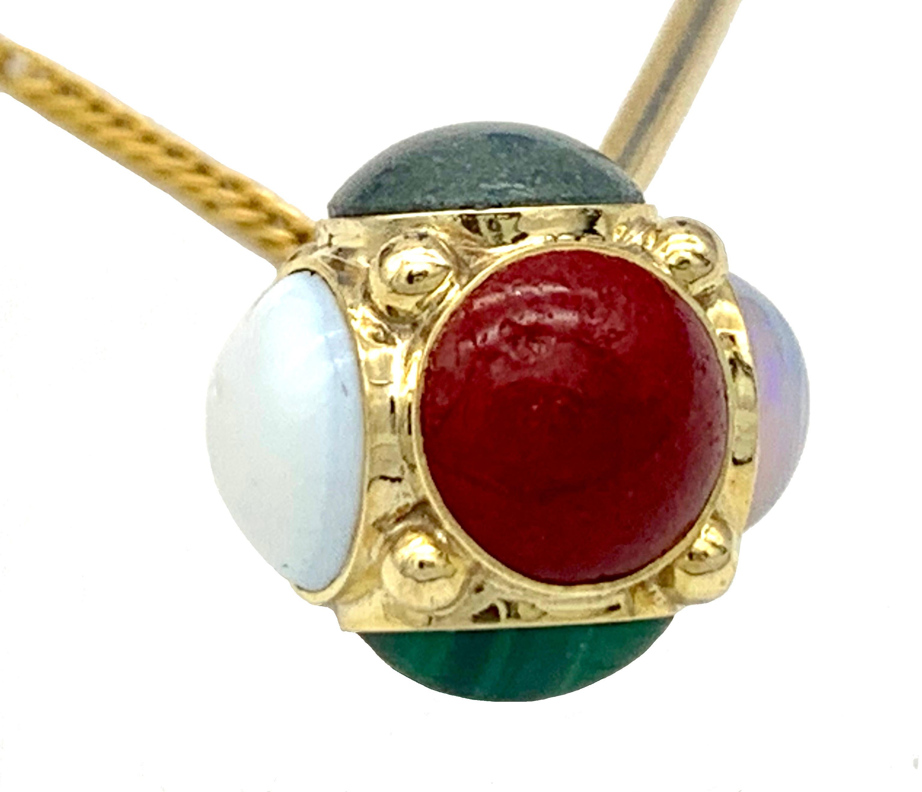 This charming gold stick pin features a variation of hard stone cabochons, tiger eye, malachite, opal   set in 14 karat gold. The principal stickpin is joined by a gold chain to a second, smaller stickpin with a simple small cube. Fashion and safety