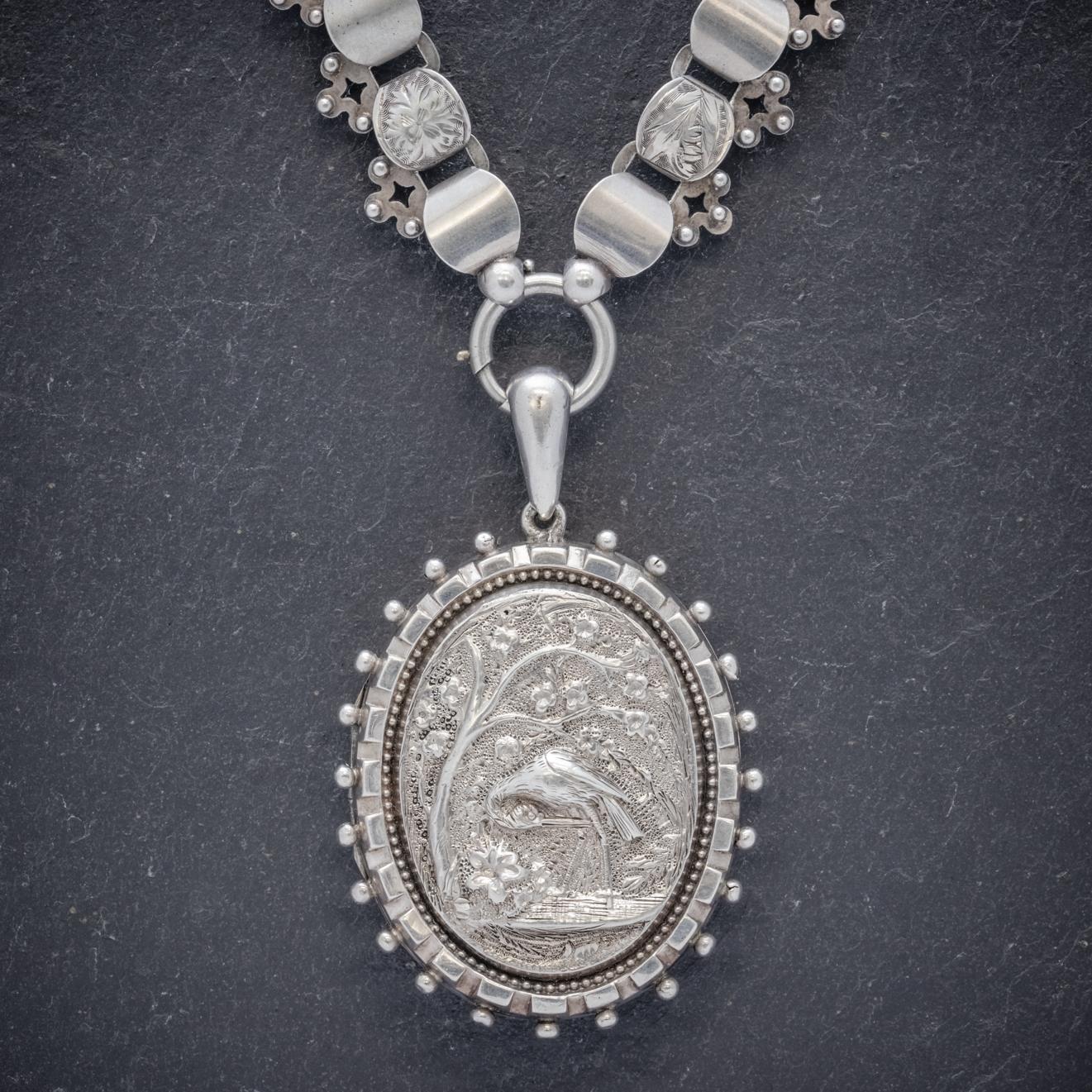 A wonderful antique Victorian collar featuring a large Sterling Silver Locket engraved with a lovely high relief image of a stork standing in a river under a tree. 

The locket is bordered by a frame of Silver balls and opens up so that two