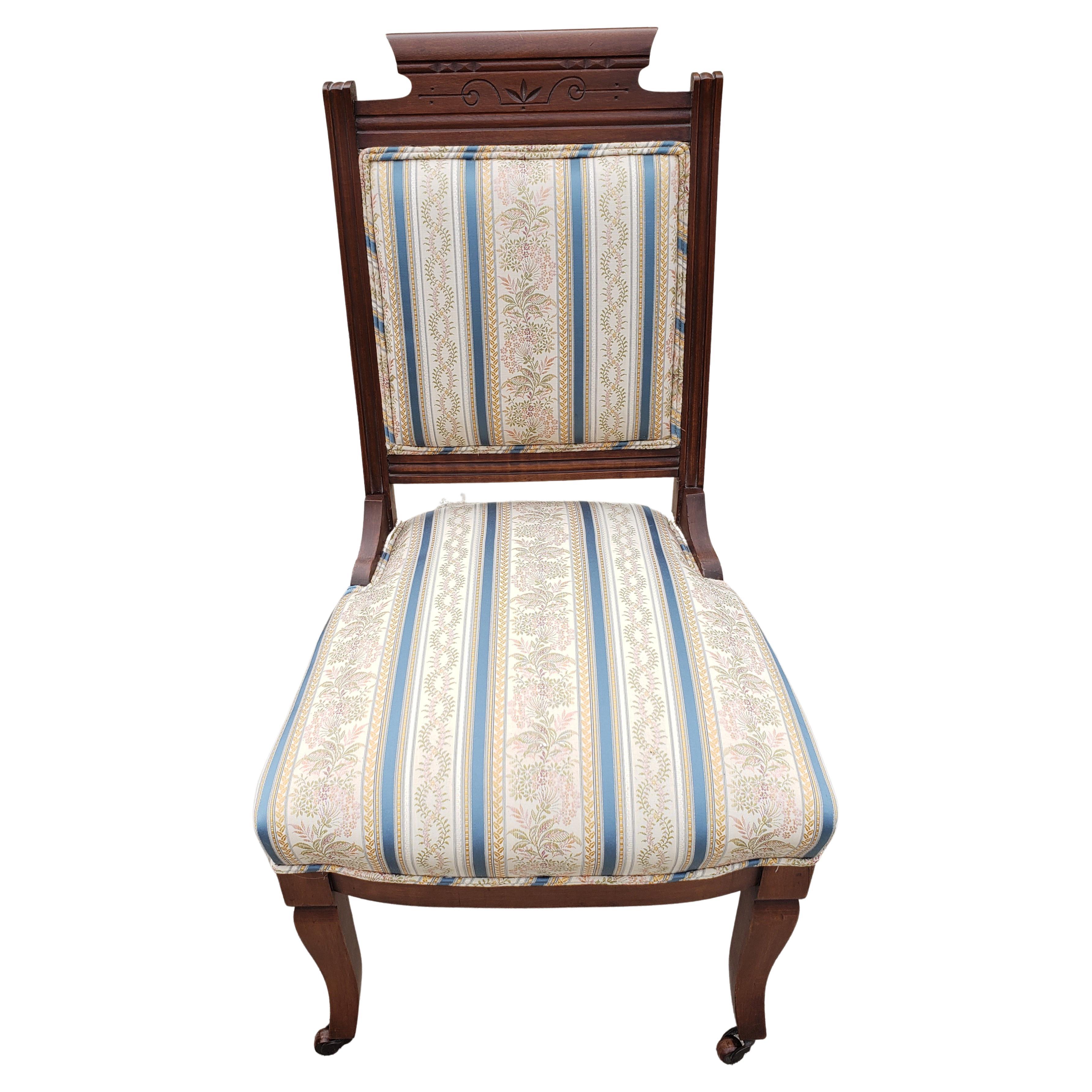 Antique Eastlake Parlor chair from the Victorian Era approximately the late 1880's - 1890's with original wood front wheels. Very Good Condition. Professionally Re-Upholstered a few years ago. Seat is firm and upholstery in very good shape and