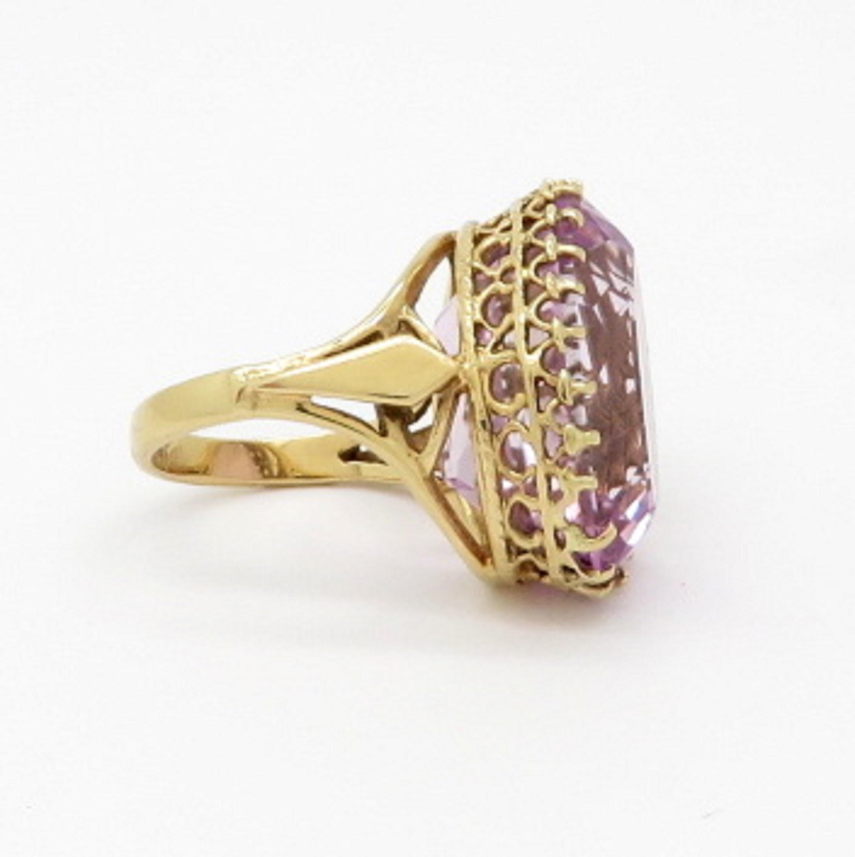 Antique Victorian style 14K yellow gold oval Kunzite fashion ring.  Showcasing one oval brilliant cut fine quality Kunzite gemstone weighing approximately 24.50 carats. The ring features openwork detailing and has a high polish finish. It is a