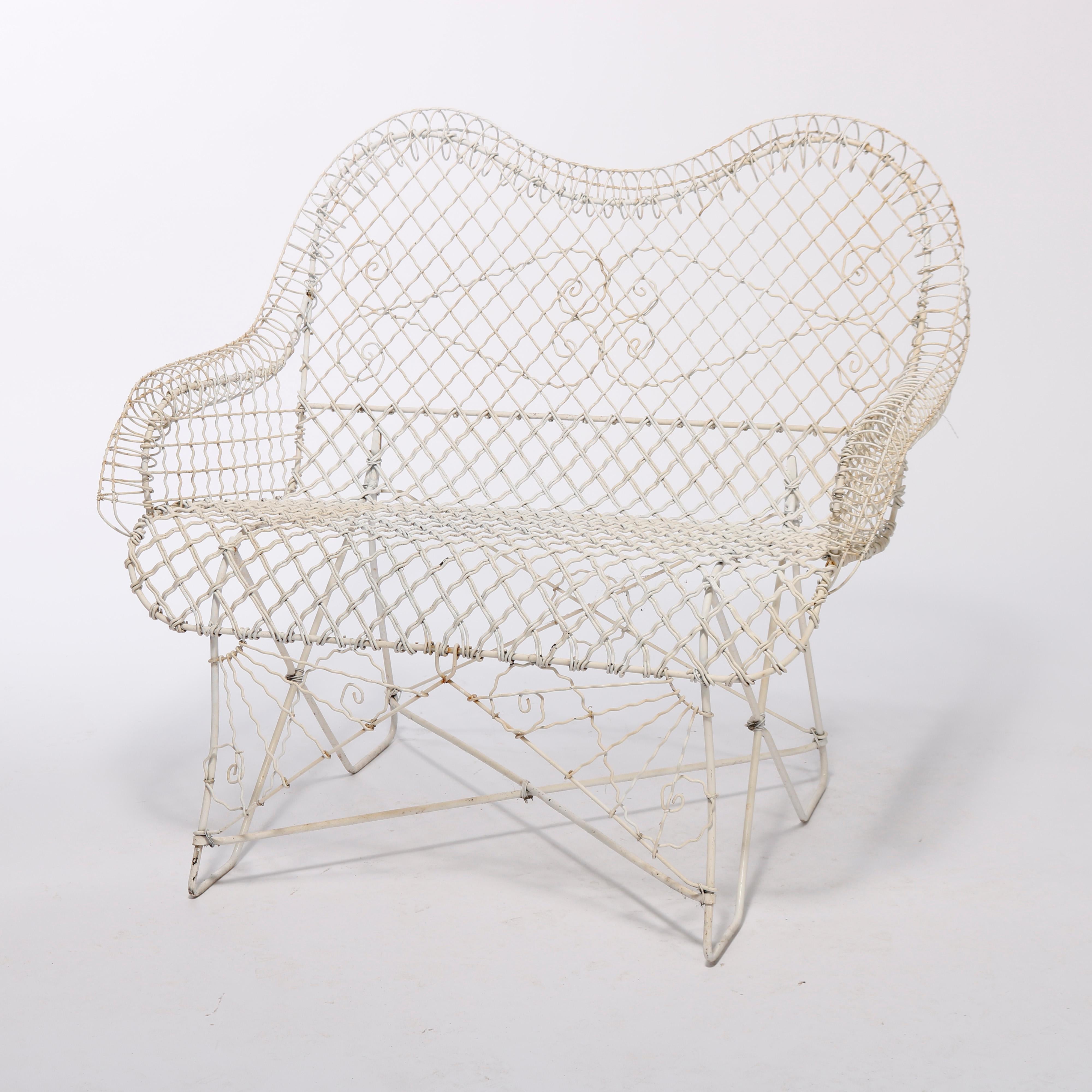 An antique Victorian style garden seat offers metal wire mesh construction with scroll form arms and scroll elements throughout, 20th century

Measures - 35''H x 39.5''W x 26.25''D.
 