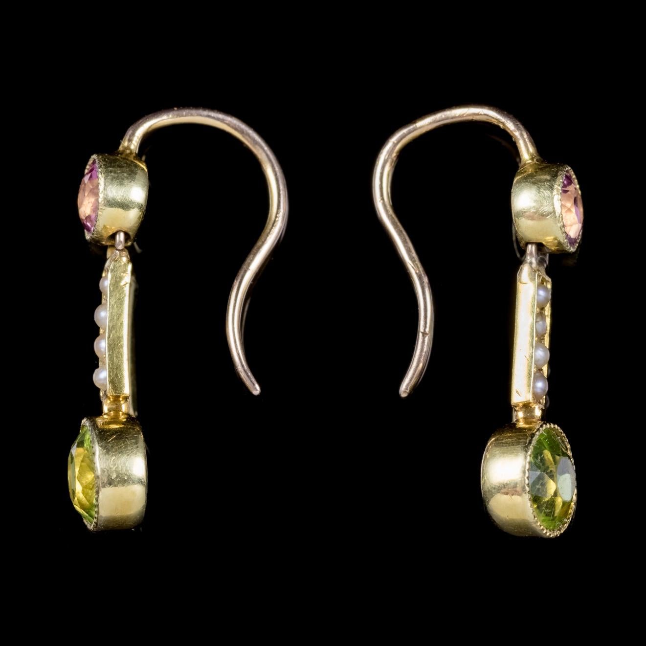 A fabulous pair of antique Victorian Suffragette drop earrings C. 1900, set with a green 0.22ct Peridot, a violet 0.10ct Amethyst and four creamy white Pearls. 

Suffragettes liked to be depicted as feminine, their jewellery popularly consisted of