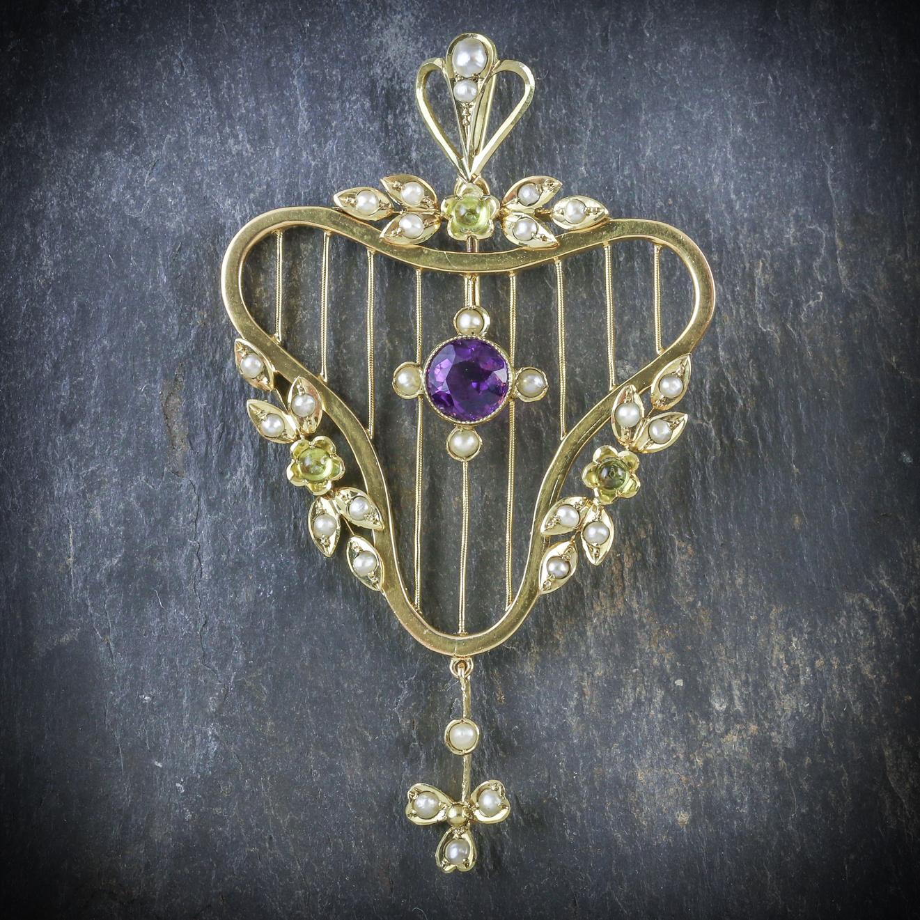 A stylish antique Victorian Suffragette pendant set in 9ct Yellow Gold and adorned with green Peridots, creamy Pearls and a violet Amethyst in the centre

The piece is beautifully made with a unique fret work that's decorated with floral motifs and