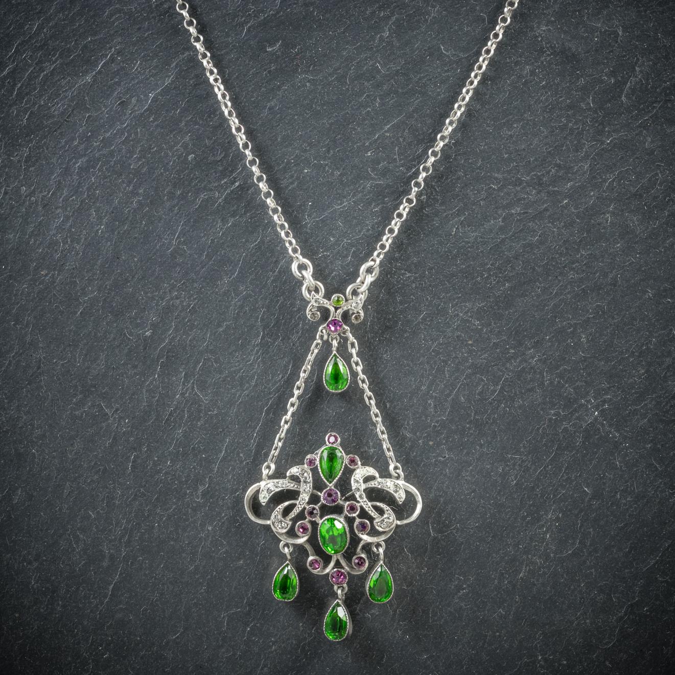 This wonderful antique Victorian pendant necklace was made representing the Suffragette movement, Circa 1900

The fabulous pendant is decorated in appox. 2.4ct of green Tourmaline, 0.6ct of Amethyst and 0.6ct of white Paste

The pendant boasts three