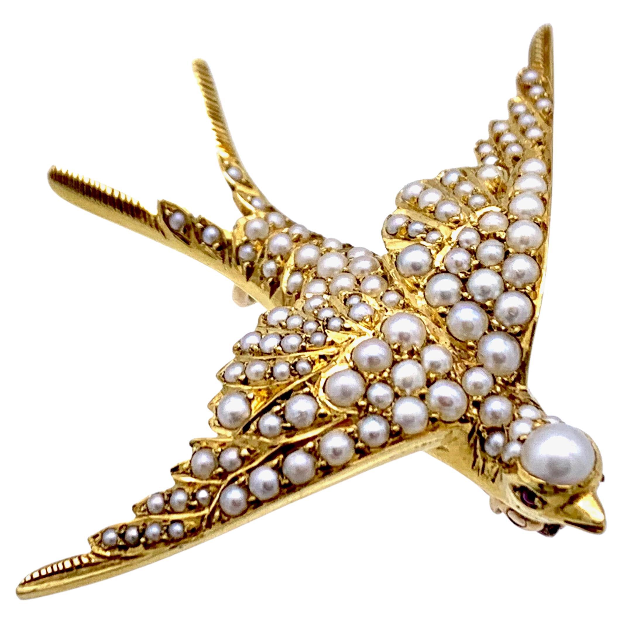 Cette magnifique hirondelle en plein vol a été réalisée à la main en or 14 carats et est entièrement sertie de perles orientales.