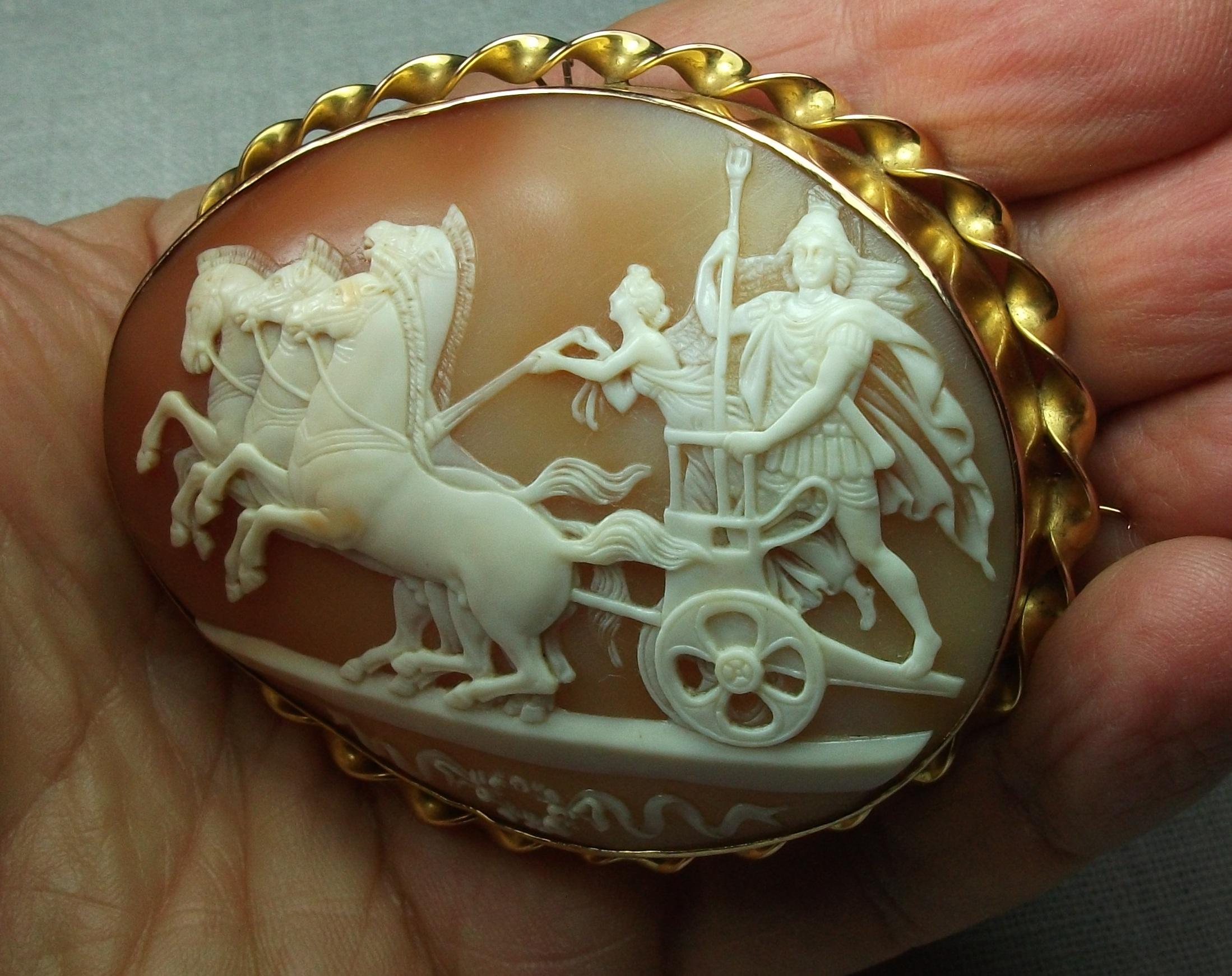 This is a Museum Quality shell cameo brooch depicting a rare subject, Alexander the Great in his Triumphal Chariot companied by Nike, the Goddess of Victory, entering in Babylon. The carver just reproduced all the details of the sculpture on this
