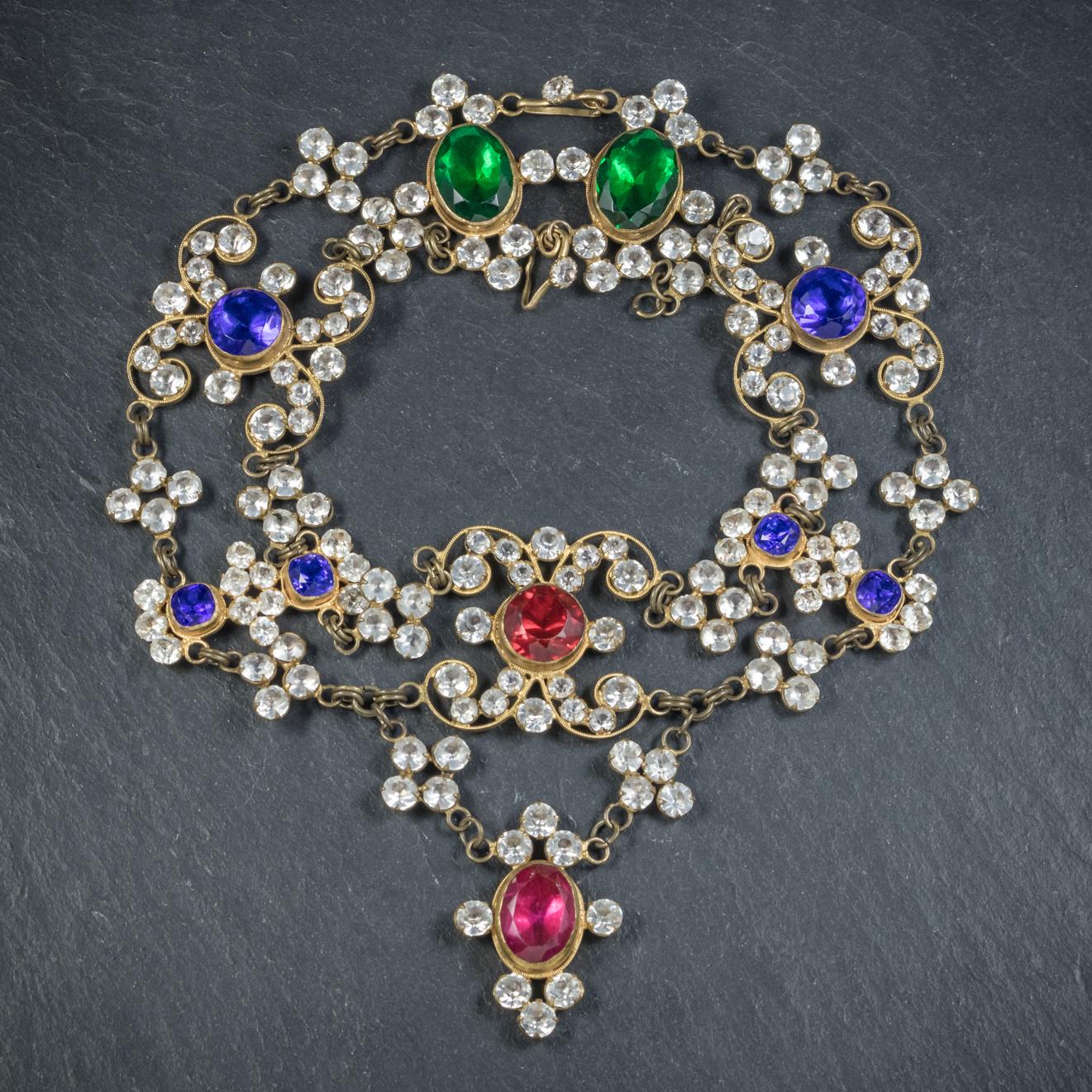 This spectacular large antique coloured Paste Stone necklace is Victorian, Circa 1900. 

The fabulous piece is made up of fancy golden links decorated in large green, blue and red Paste Stones with smaller white Pastes glistening in-between.

The