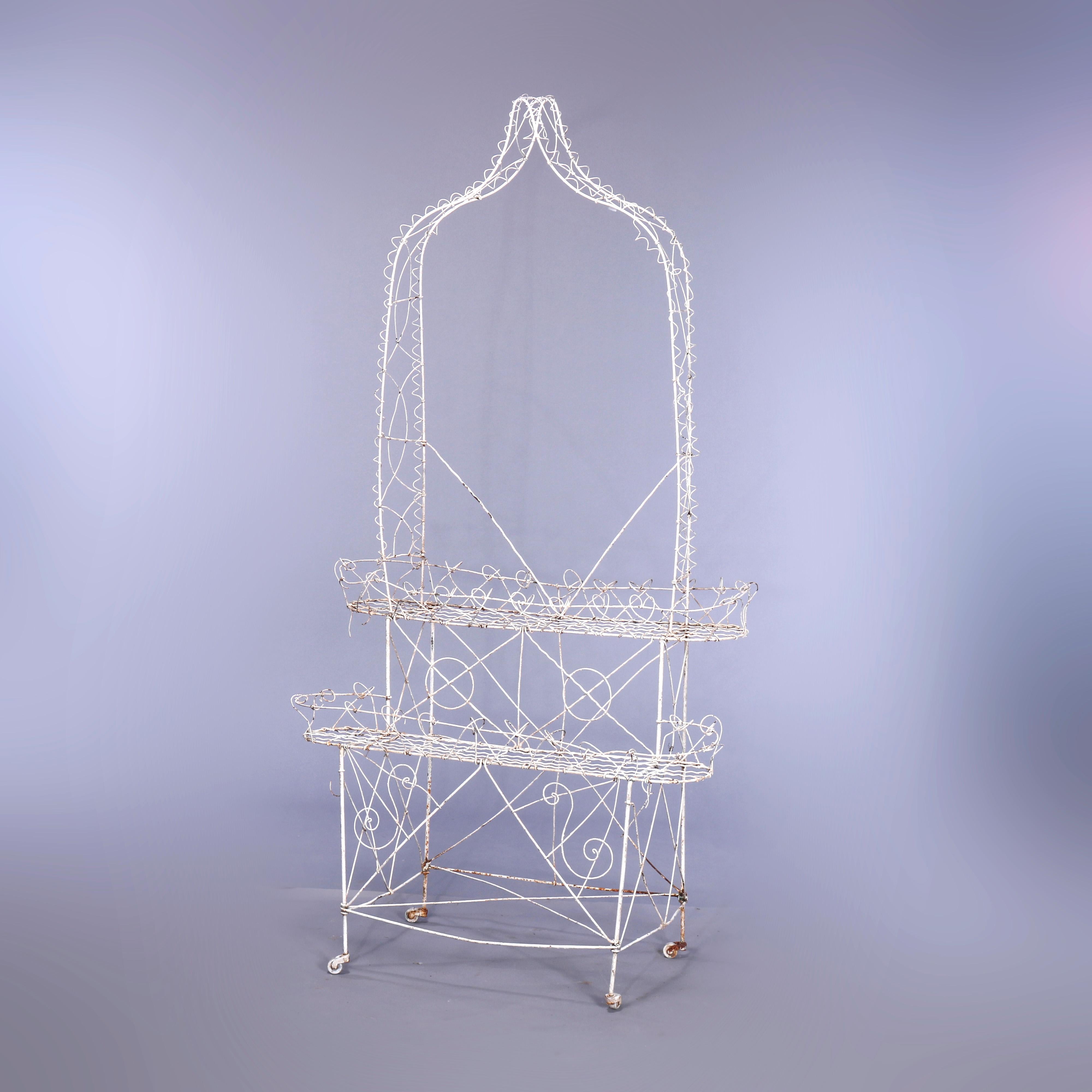 An antique Victorian plant stand offers scrolled wire construction in arbor form with two offset tiers of plant trays, c1890.

Measures - 72.5''H x 37.25''W x 18.5''D.
