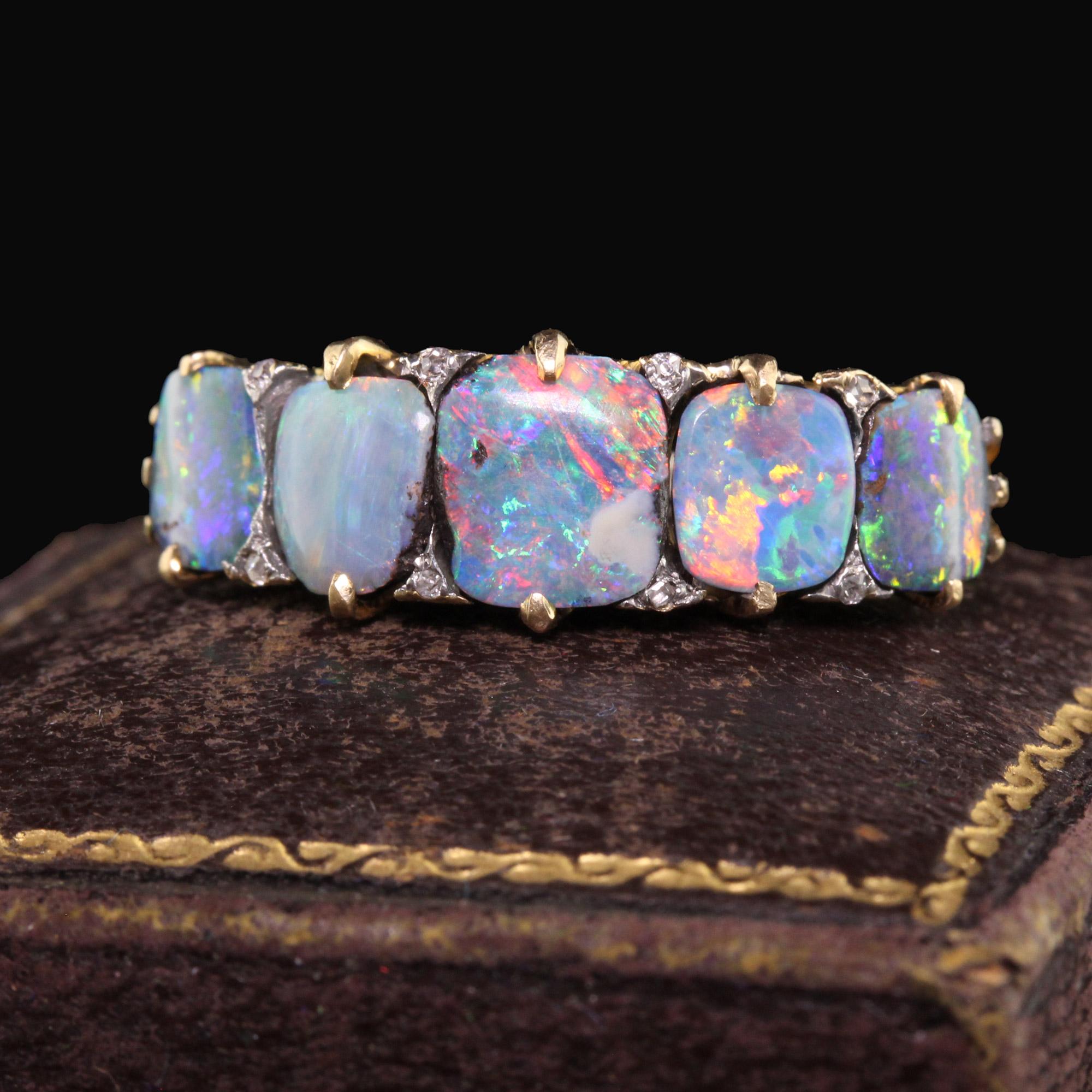 Beautiful Antique Victorian Tiffany and Co Boulder Opal Five Stone Wedding Band - Size 8. This incredible ring is crafted in 18k yellow gold. The ring holds five gorgeous Australian boulder opals that have a full array of color including blue,