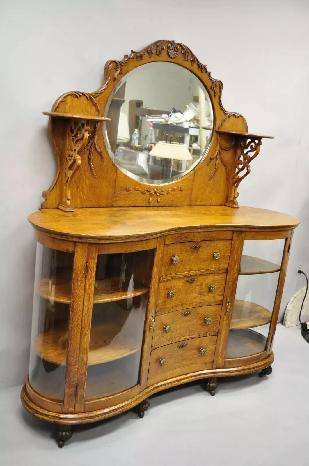 Antiguo Victoriano Tigre Roble Tallado Pata Curio Cabinet Base Aparador Buffet. El artículo incluye (4) paneles de cristal curvado, frontal en serpentina, panel trasero de espejo de cristal biselado, 2 estantes superiores, patas curvadas con ruedas,