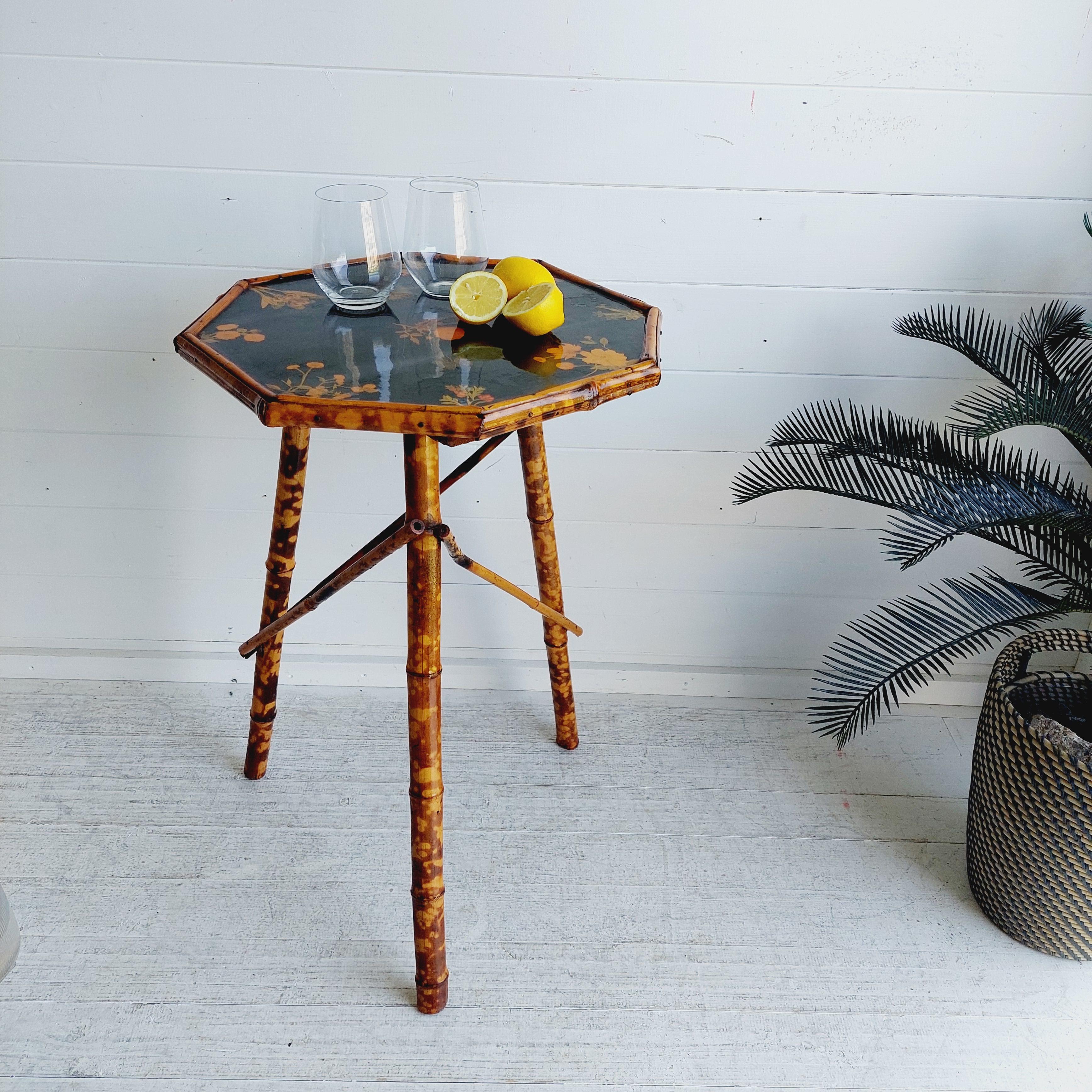 Victorian period tiger bamboo side table.
Bamboo & Chinoiserie Table
Circa early 1900s
Aesthetically appealing and a unique piece of furniture

Lacquered top Occasional Table with plants, flowers and butterfly motif on black background.
Octagonal