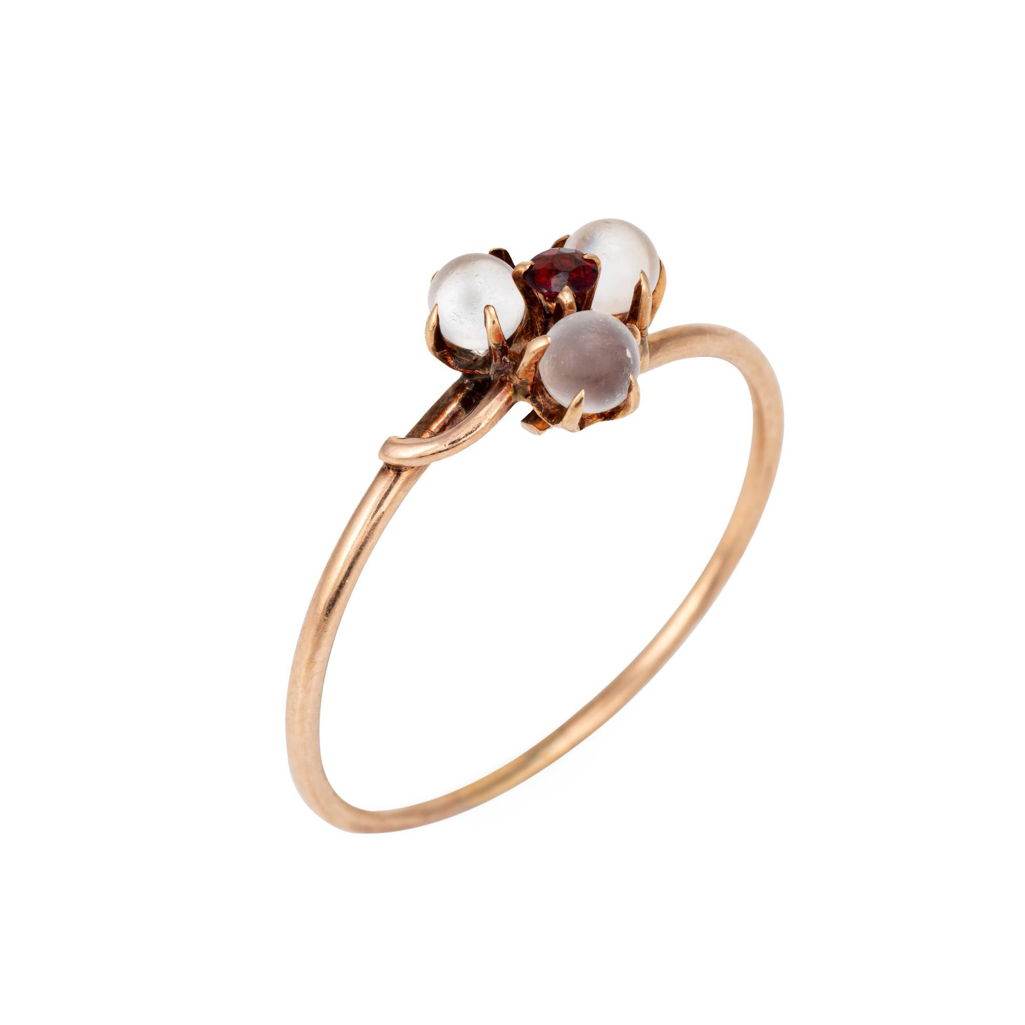 Finely detailed antique Victorian moonstone & garnet ring (circa 1880s to 1900s), crafted in 14 karat rose gold. 

Three moonstones measure 3mm each. One estimated 0.03 carat garnet is set to the center of the mount. The moonstones are in good