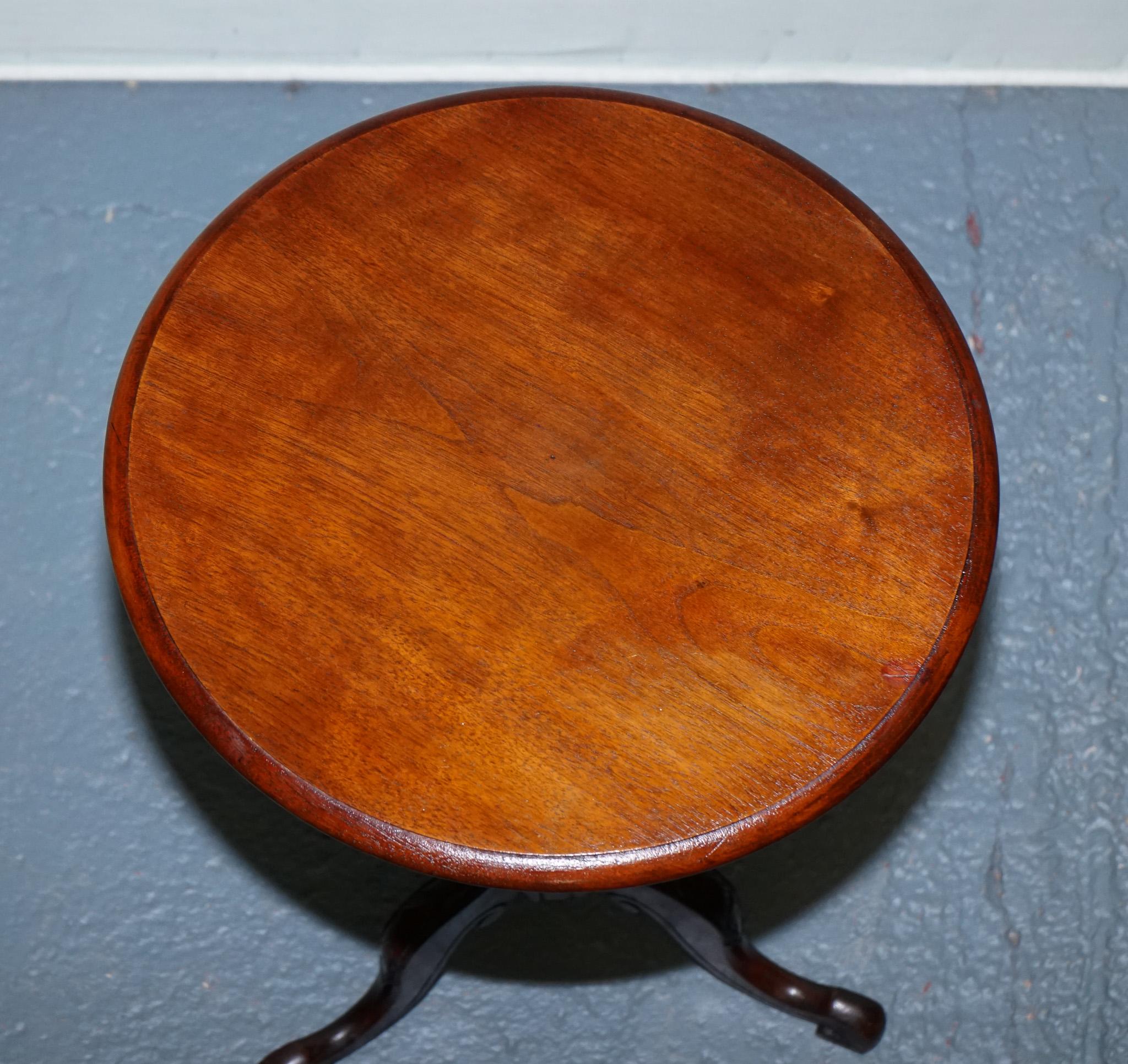 
Antiques of London



Elegant Victorian mahogany tripod side table, dating from circa 1900, featuring a round solid mahogany top on a finely turned pedestal column. The table is supported by three beautifully carved cabriole legs terminating in