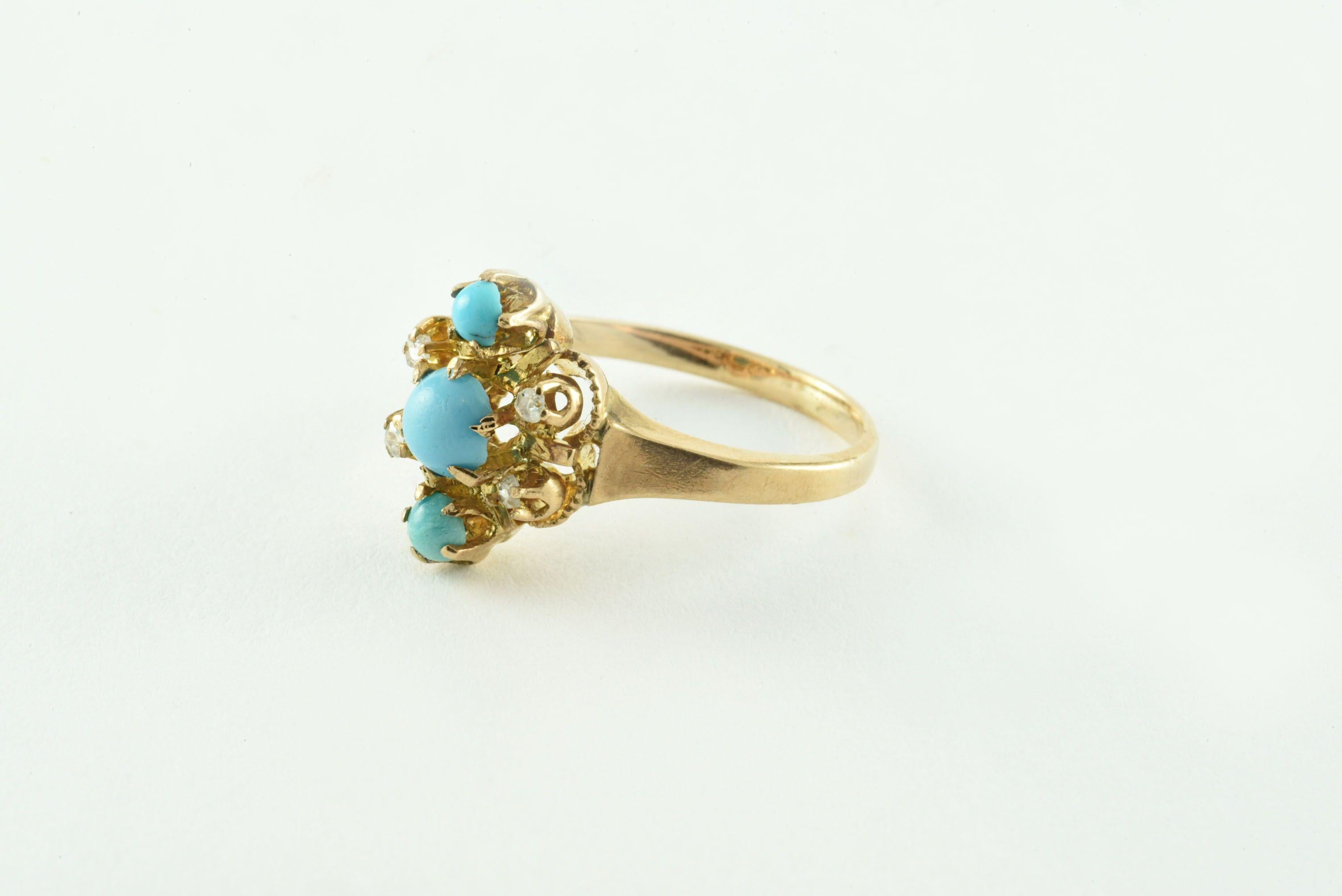 Dieser antike Ring zeigt ein zartes Trio aus persischen Türkissteinen in einer vertikalen Reihe und vier Diamanten im Rosenschliff, Farbe H-I, Reinheit VS-SI, in einer hübschen floralen Einfassung, gefasst in 10kt Gelbgold. 
