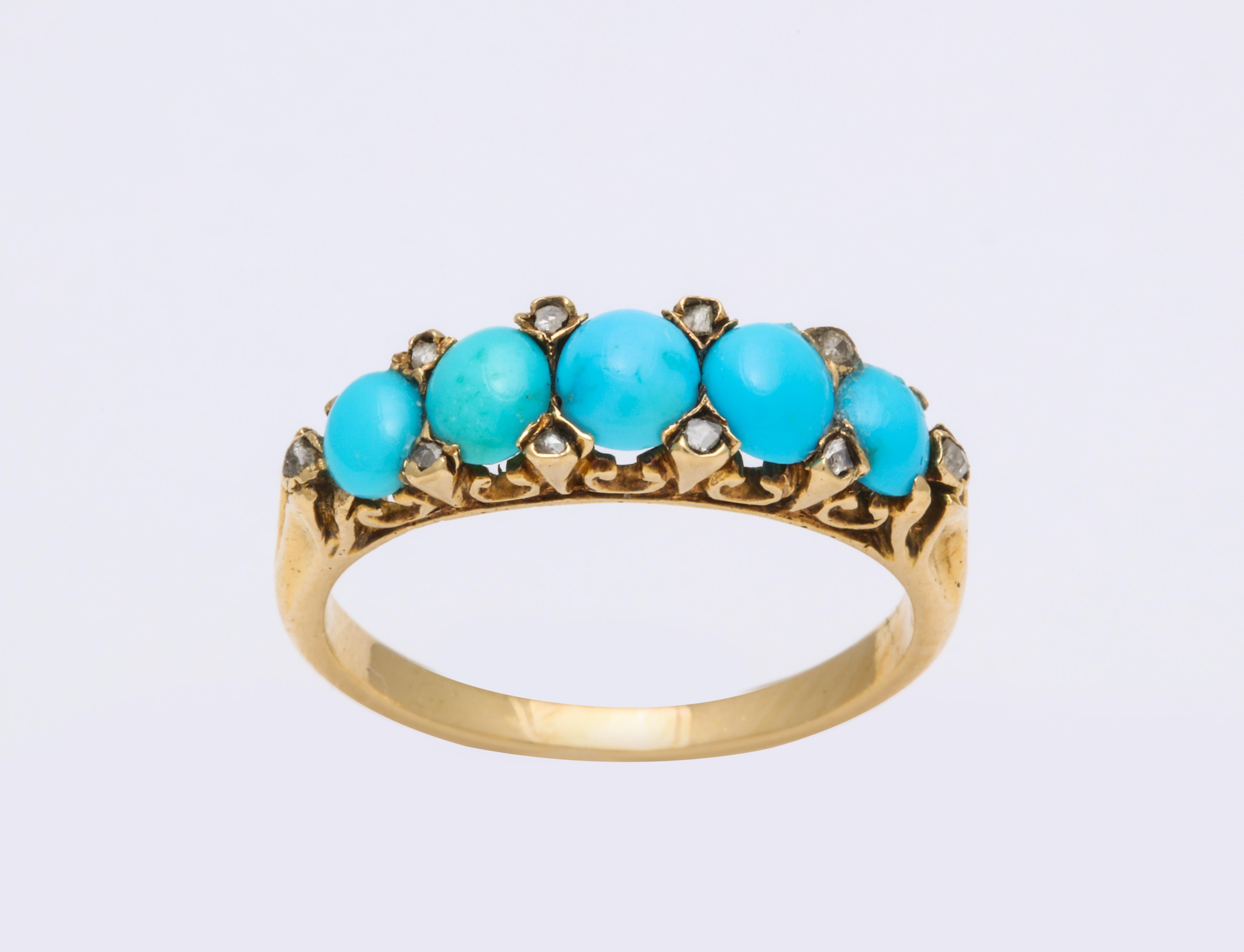 A pristine band of bright, beautifully matched oval turquoise from Persia are sparked by the tiny diamonds interspersed in their lovely architectural 15 kt gold setting. Regardless of theIr small size, the diamonds sparkle in the light and give the