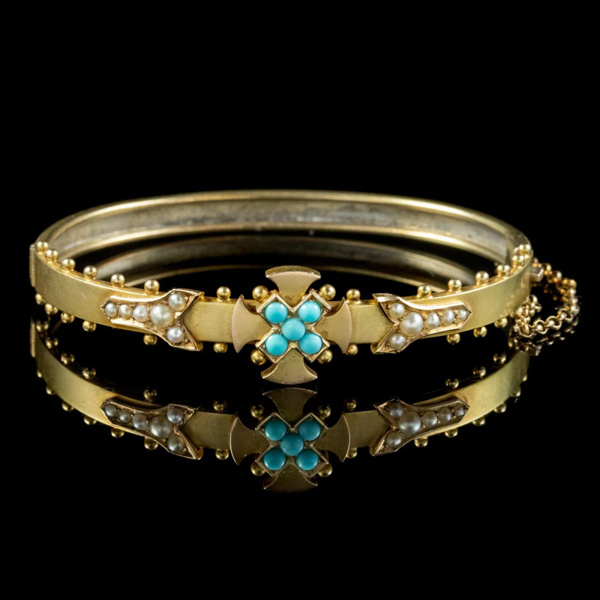 An exquisite antique Victorian bangle from the late 19th Century featuring a Celtic cross on the front decorated with five turquoise and a row of pearls at each side.

The band is crafted in 15ct gold and held securely around the wrist by a box