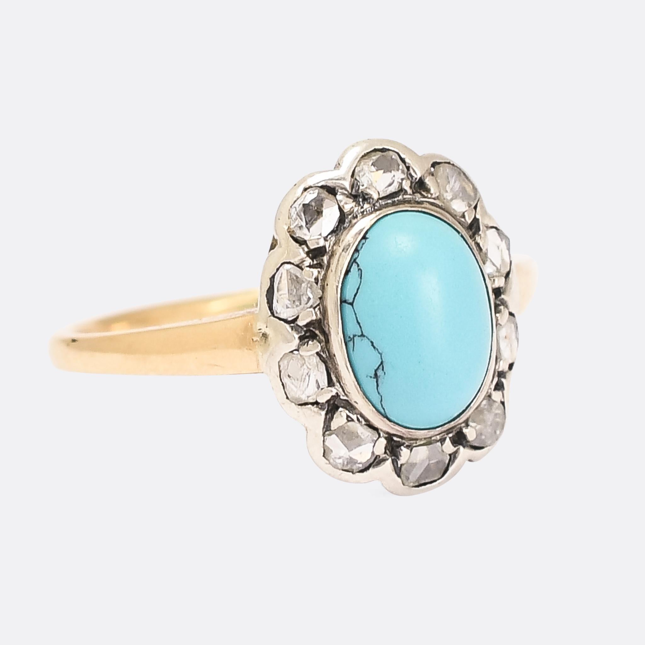 The most lovely Victorian flower cluster ring dating from the turn of the 20th Century. It's set with a highly domed turquoise matrix cabochon, with a rose cut diamond surround - each diamond set in silver to mimic petals. The band is modelled in 15