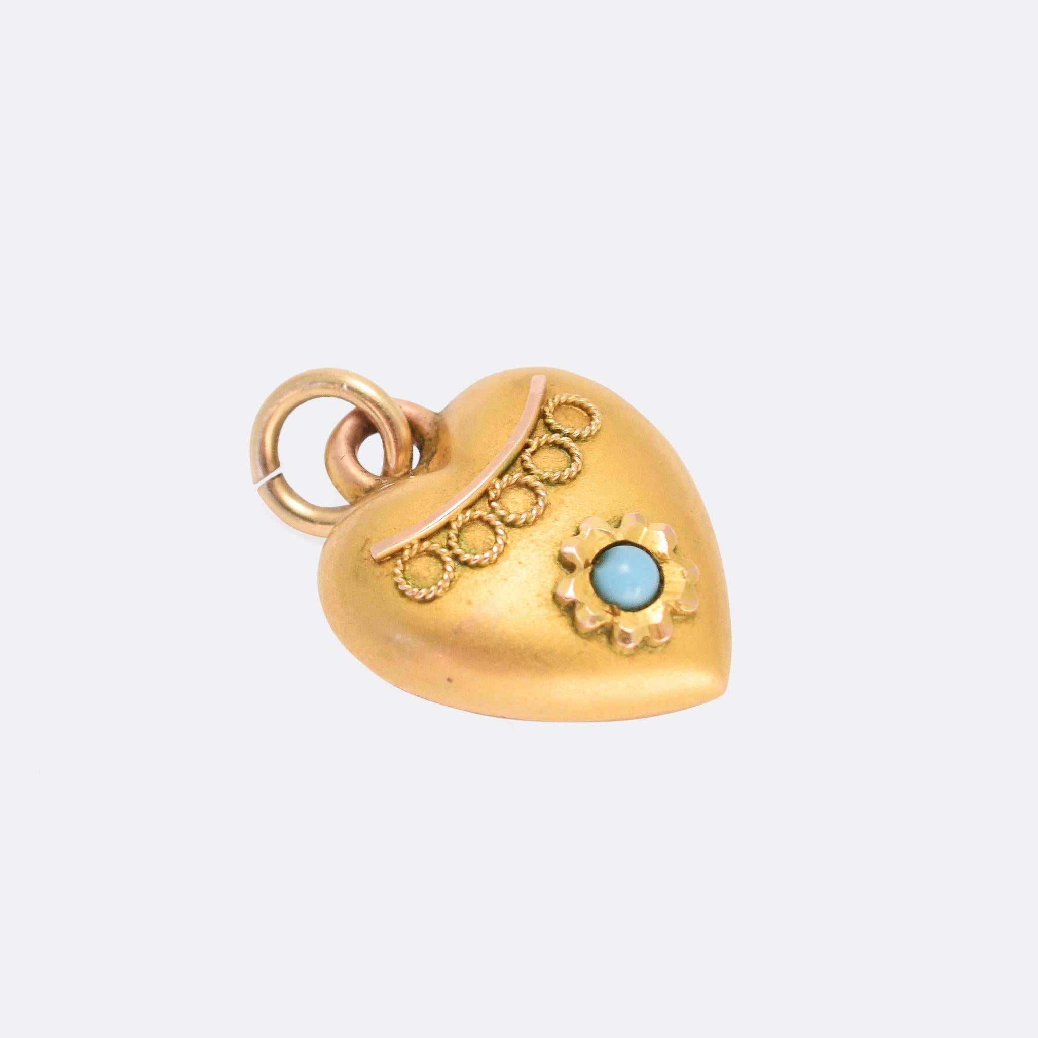An incredibly sweet tiny puffed heart charm, with Etruscan style detailing and set with a single turquoise cabochon. It was made in England in the late 19th Century; small but perfectly formed. A great addition to a charm bracelet or charm holder,