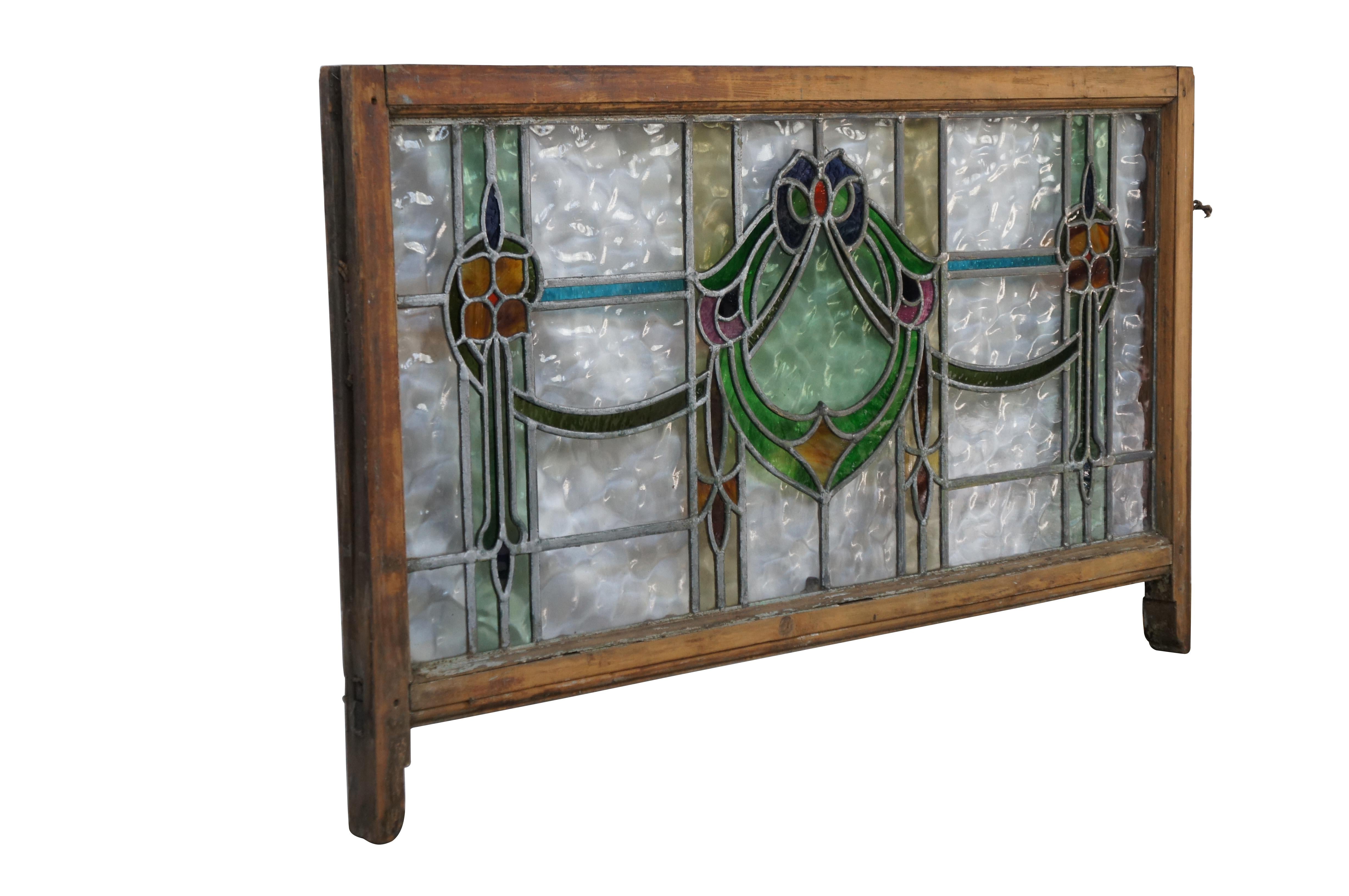 19th Century American Victorian Art Nouveau leaded stained glass transom window panel.  Features a beautiful ribboned motif with flowers.  Includes Pebbled glass and leaded green, amber, blue and yellow.  

Dimensions:
25.5