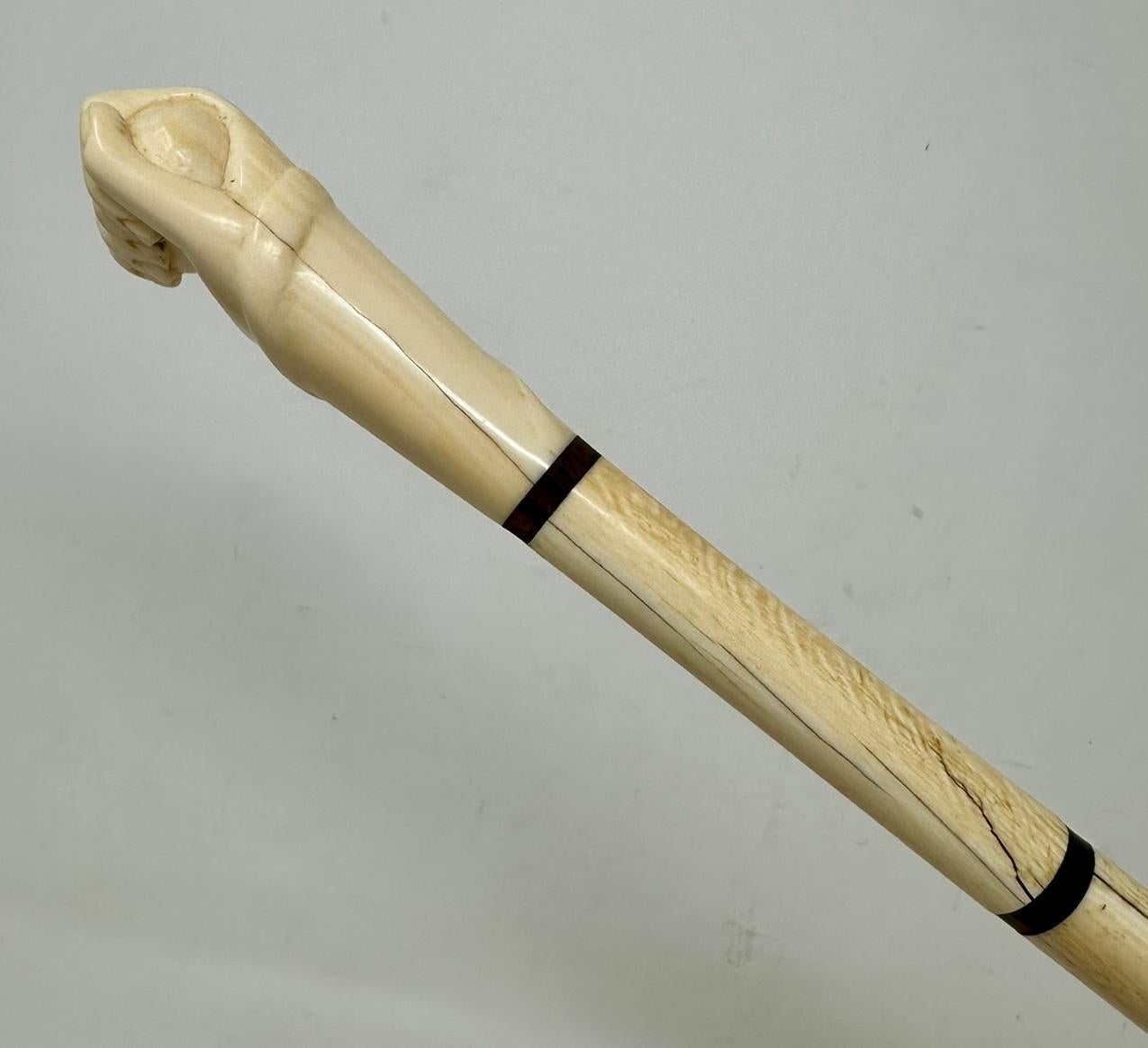 A Very Fine & Rare Example of a Mariner’s Whale Bone Walking Cane of exceptional quality. First half of the Nineteenth Century, possibly of English origin. 

The hand carved decorative grip modelled as closed fist holding a ball with a carving of a