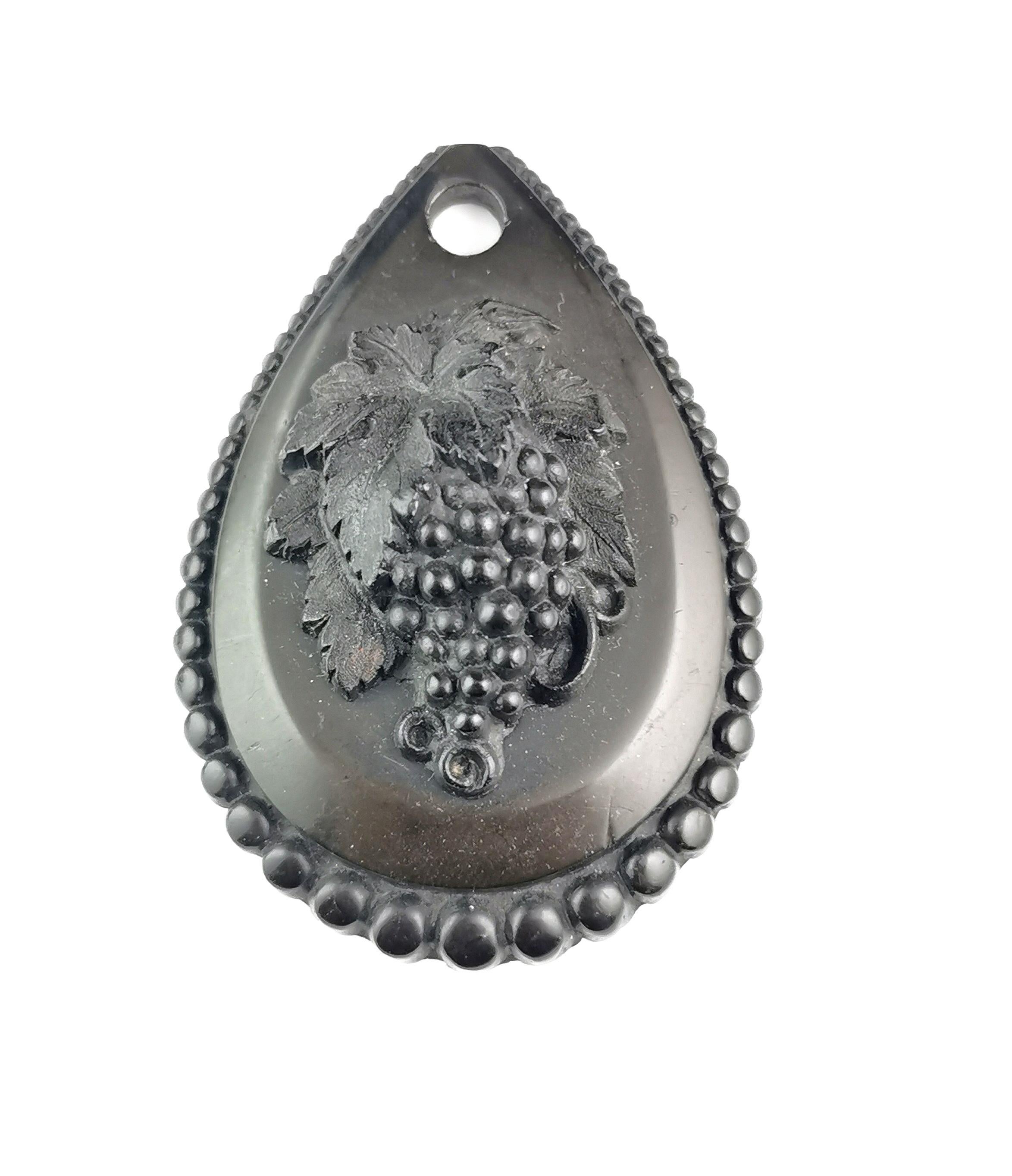 An attractive and interesting antique Victorian grapes pendant.

The pendant is crafted in rich black Vulcanite and it a teardrop shaped pendant with a beaded border and an applied central motif of a bunch of grapes.

It has a wonderful 3d effect to
