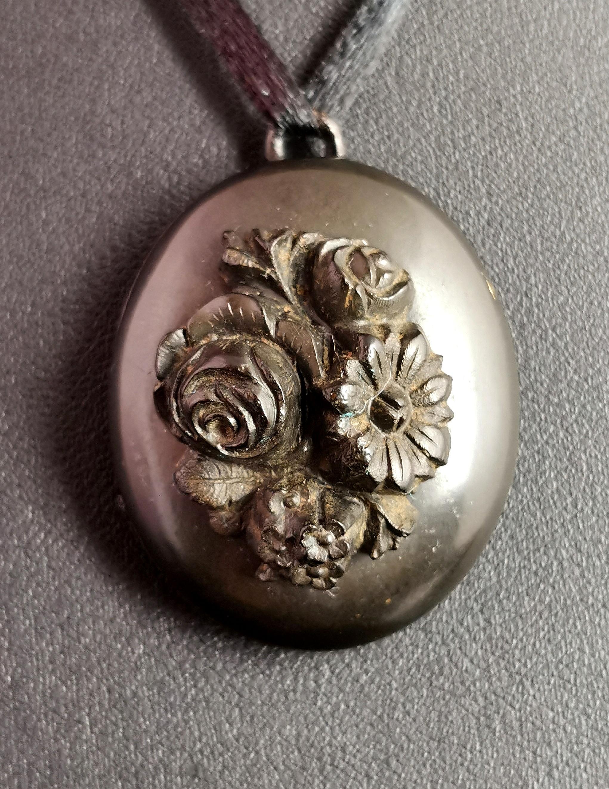 A beautiful antique Victorian mourning locket.

It is a chunky locket made from vulcanite with an applied spray of flowers to the front.

It opens to reveal two compartments for storing photographs but not glazing.

Vulcanite was a popular material
