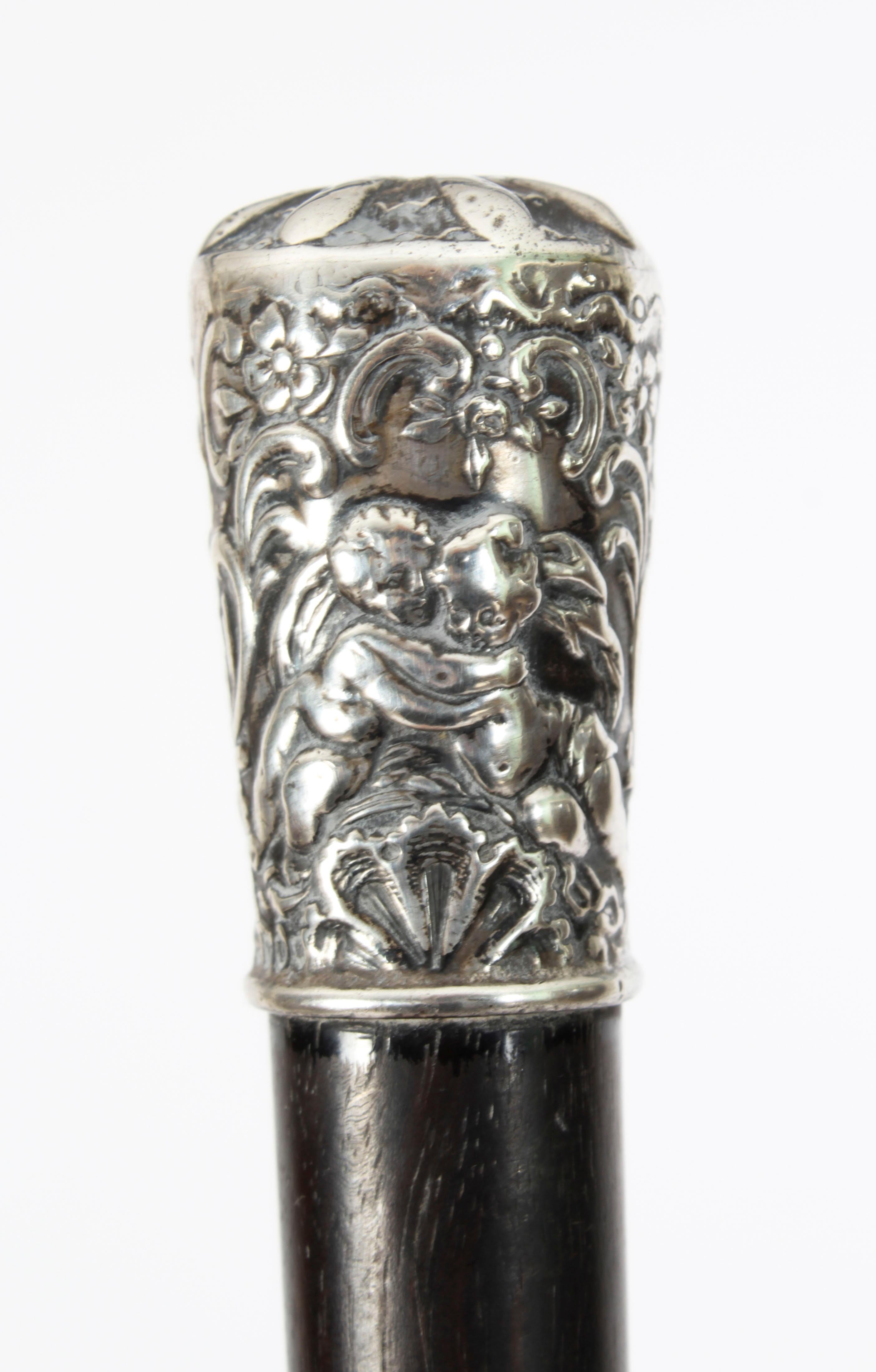 This is a superb Victorian silver  ebonised walking stick by Benjamin Mounyigue with the hall marks for London,  1894.
  
This decorative walking cane features a splendid silver cylindrical handle decorated with dancing cherubs on a tapering