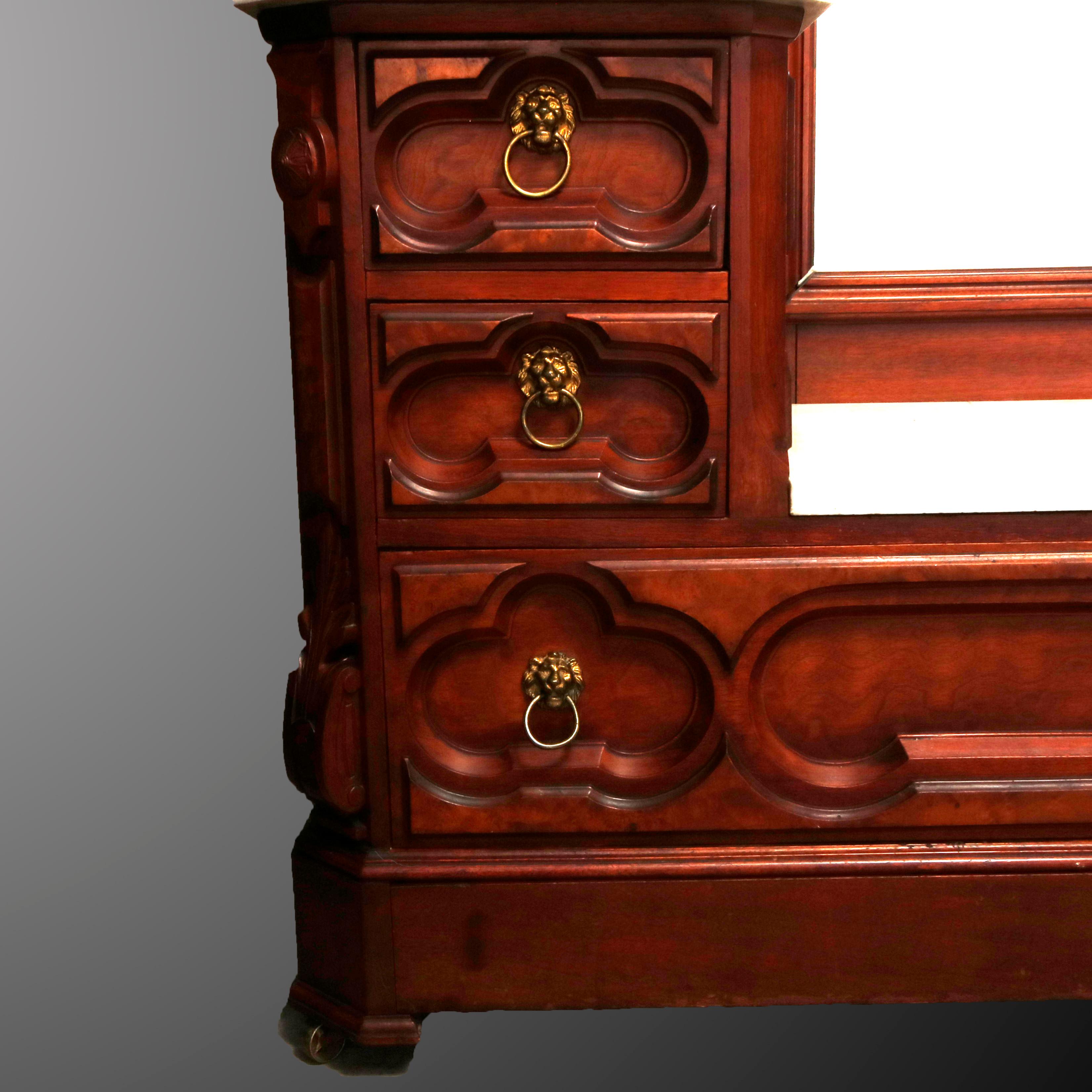 An antique Victorian dresser offers walnut construction with burl inlay having carved crest surmounting dressing mirror flanked by foliate carvings and four candle stands with drop finials over drop center case with marble top, four small drawers