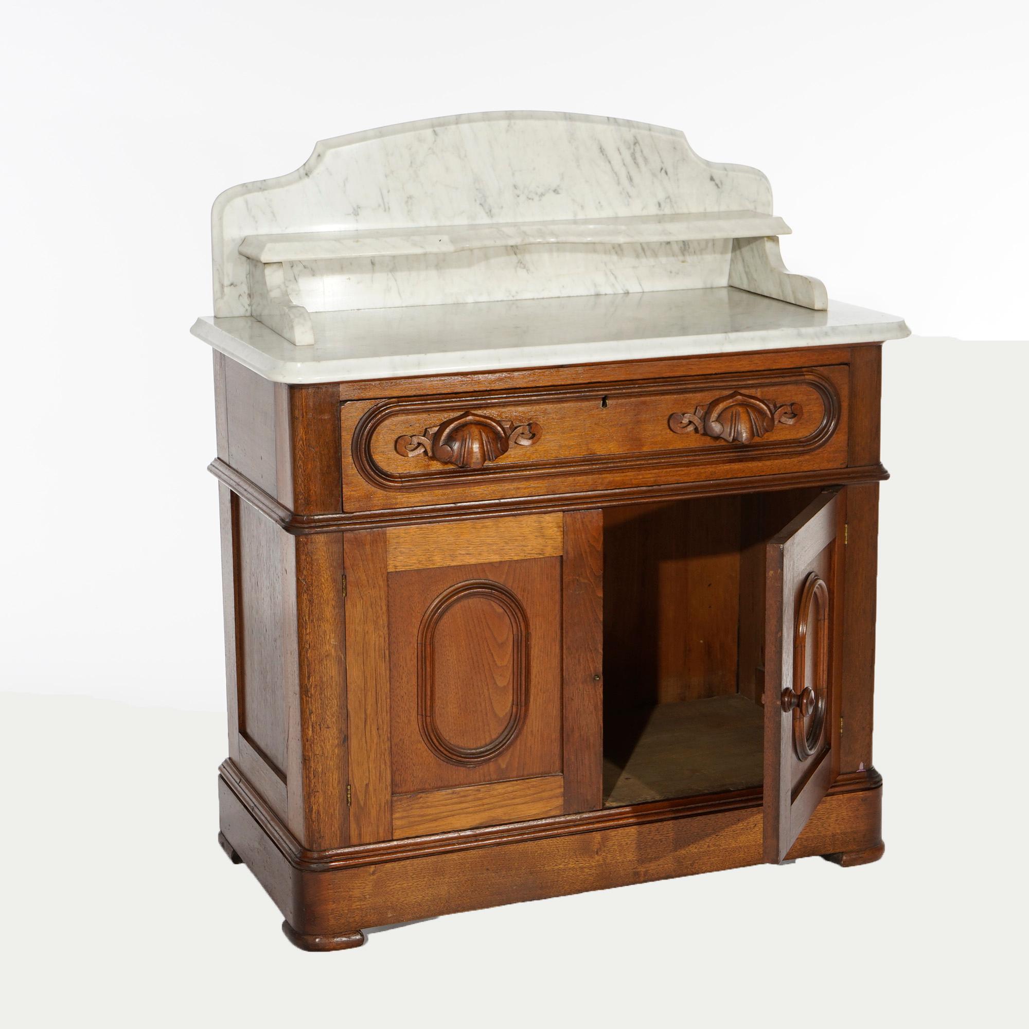 An antique Victorian washstand commode offers marble top with shaped backsplash with lower shelf over walnut case with upper drawer over double door lower cabinet, c1880.

Measures- 38.25''H x 33.25''W x 17''D.

Catalogue Note: Ask about