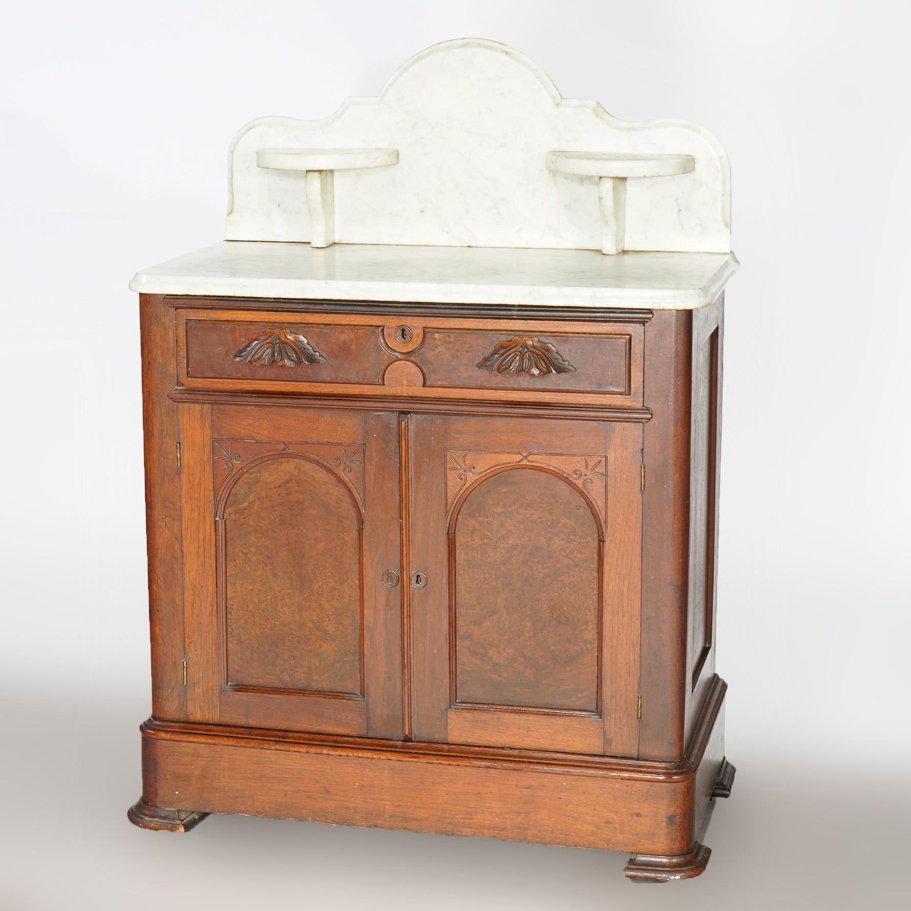 An antique wash stand offers shaped marble top with shaped backsplash having candle stands over walnut and burl base with frieze drawer over cabinet with double doors having arched panels, c1890

Measures- 43.25'' H x 32'' W x 17'' D.