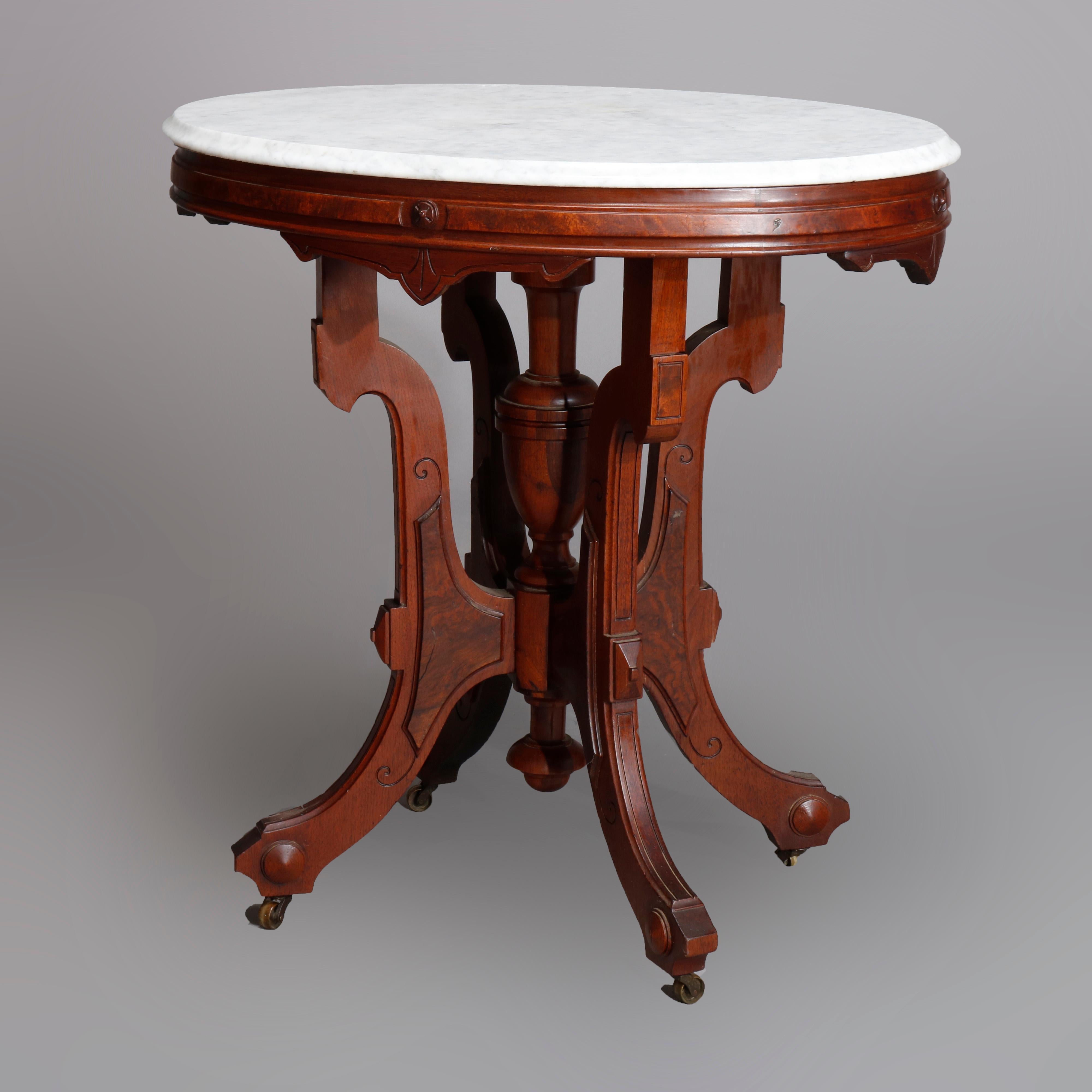 An antique Victorian parlor table offers walnut construction with beveled marble top over walnut base with burl insets and raised on scroll form legs with central turned column, c1890.

Measures: 30
