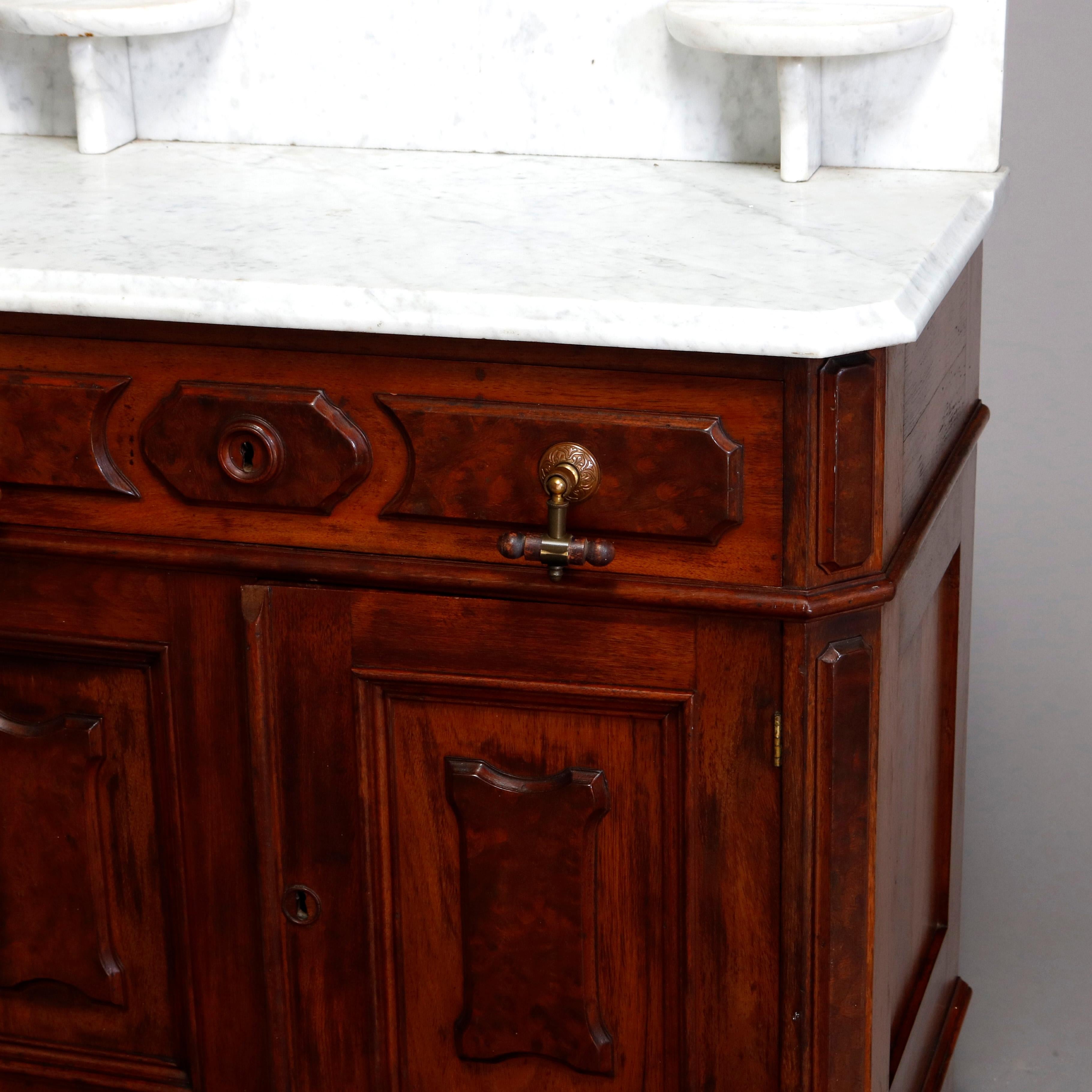 An antique Victorian washstand offers beveled marble top with backsplash and candle stands surmounting case with burl panels and having single upper long drawer over double door cabinet opening to shelved interior, c1890

Measures - 42.25
