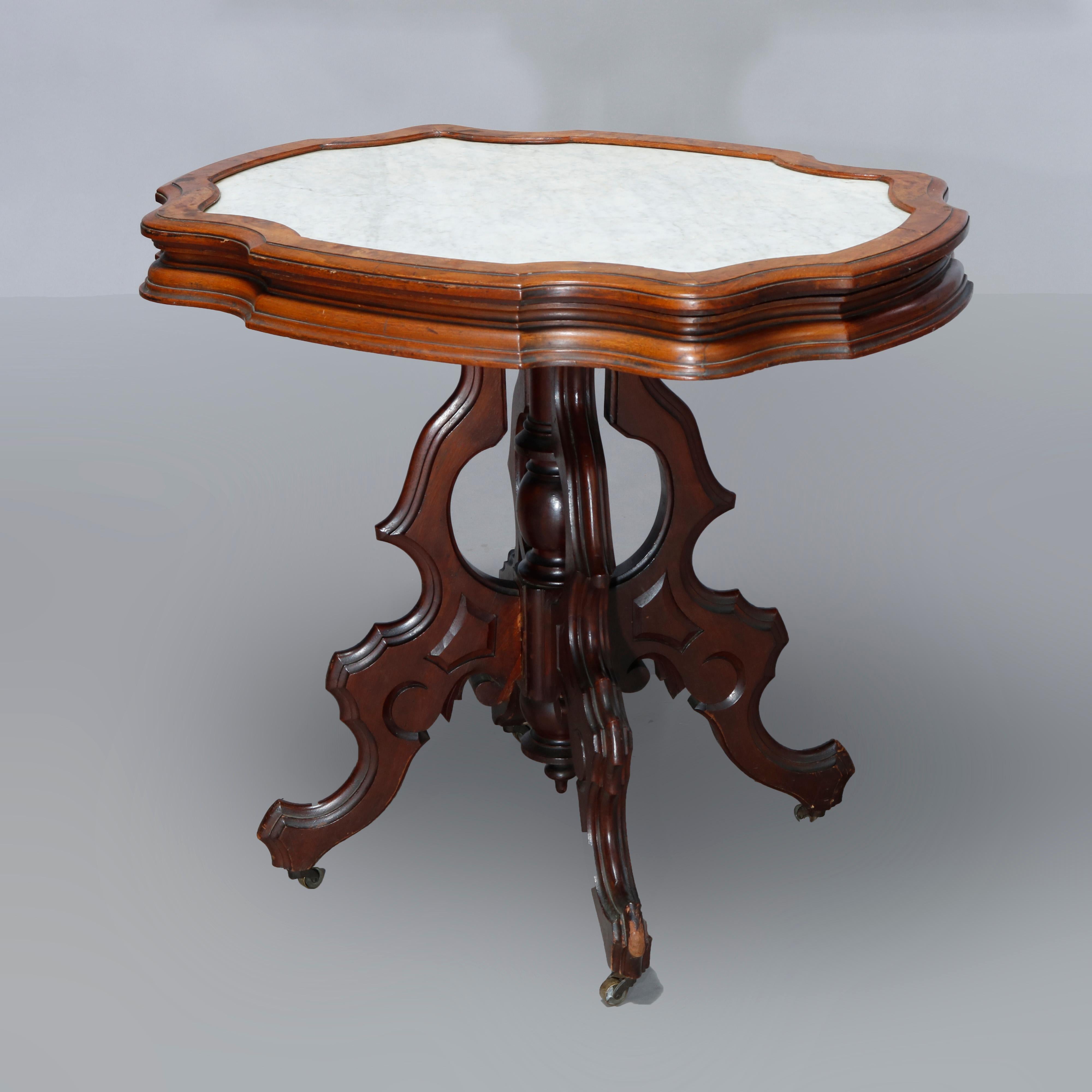 An antique Victorian parlor table offers inset picture frame shaped marble top over carved walnut and burl base having scroll form legs with central turned column and drop finial, c1890.

Measures: 29.5