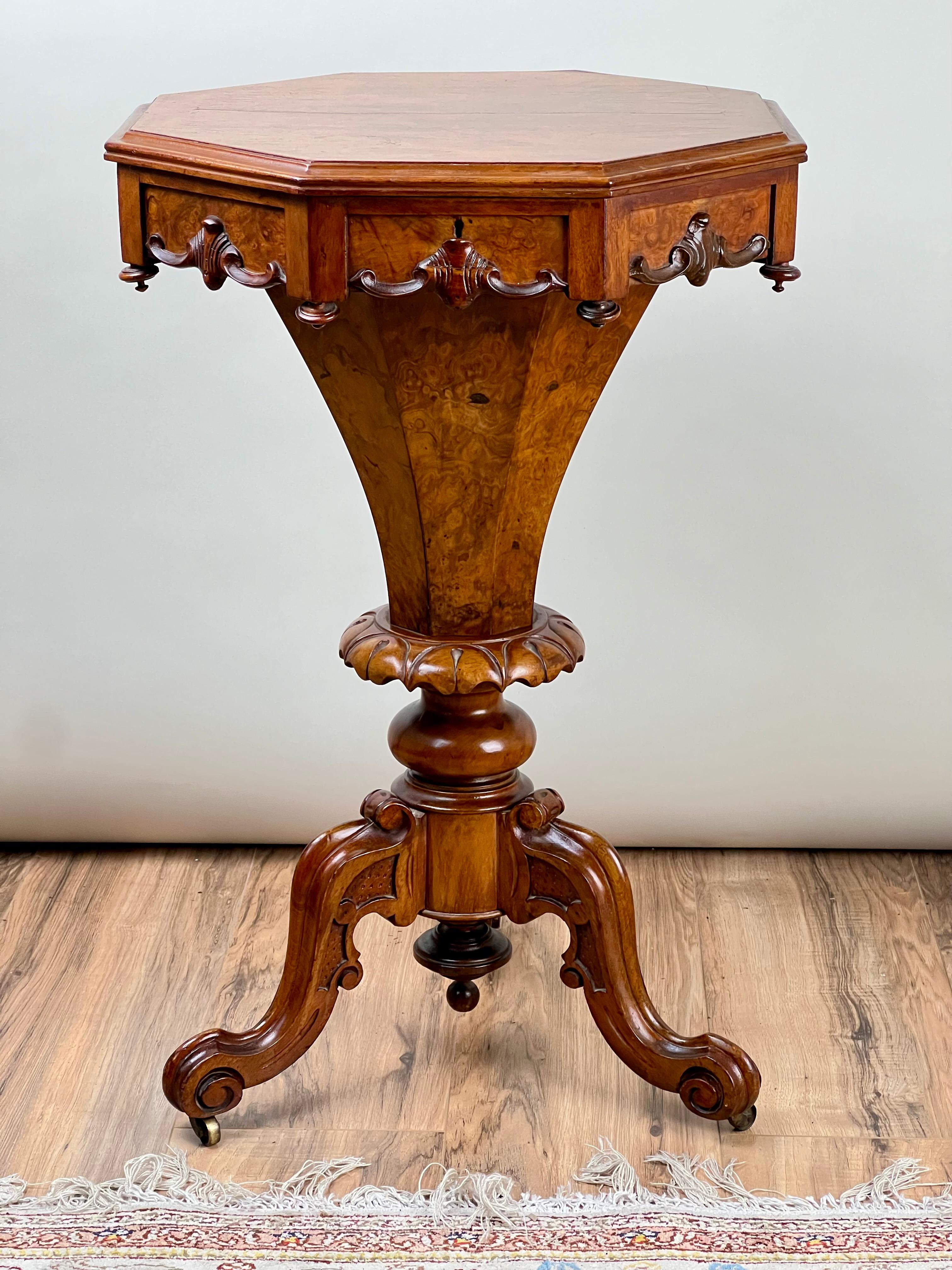 This exquisite mid-19th-century Victorian walnut burl trumpet table boasts a masterful blend of form and function. The octagonal top showcases the rich swirling grain patterns and distinctive depth of walnut burl, exuding warmth and character.