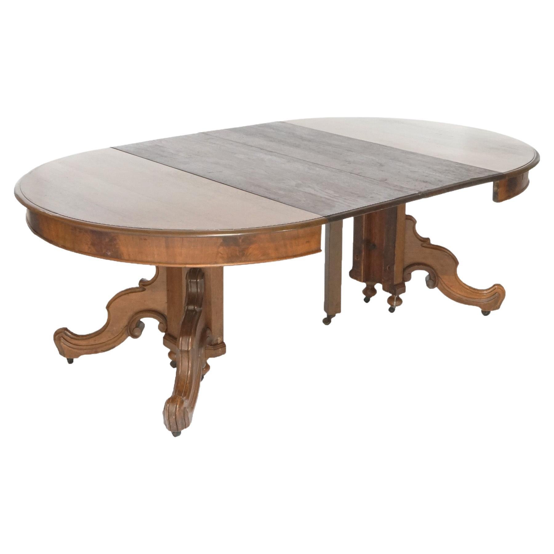 An antique Victorian dining table offers walnut construction with round top extending to accept six leaves, over split pedestal base having scroll form legs, c1890.

Measures- 29.5''H x 51.5''W x 51.5''D; with all leaves 172.5'' (14' 4.5''); 1