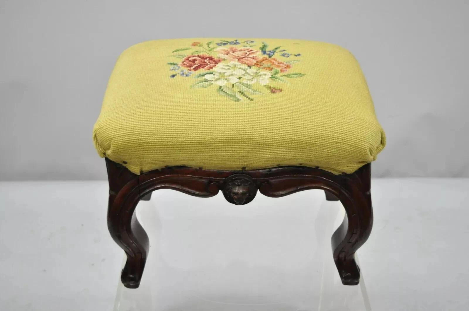 Antique Victorian Walnut Figural Lion & Female Face Needlepoint Footstool Ottoman. Item features a floral needlepoint seat, 2 lion faces, 2 female maiden faces, solid wood construction, cabriole legs, very nice antique item. Circa Early 20th