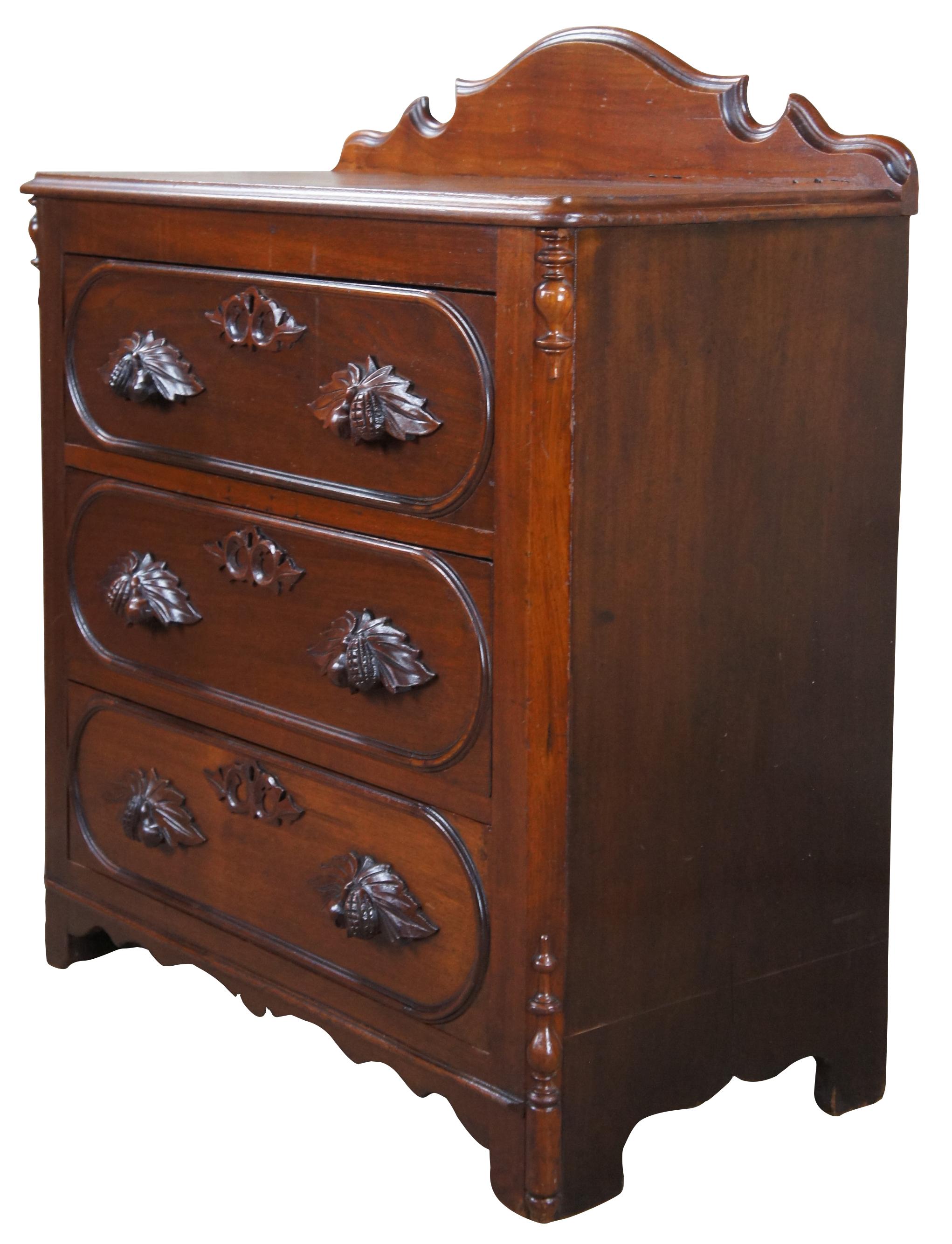Antique Victorian chest or three drawer dresser / side table / nightstand.  Made of walnut featuring serpentine backsplash with carved high relief fruit nut & berry design.

30