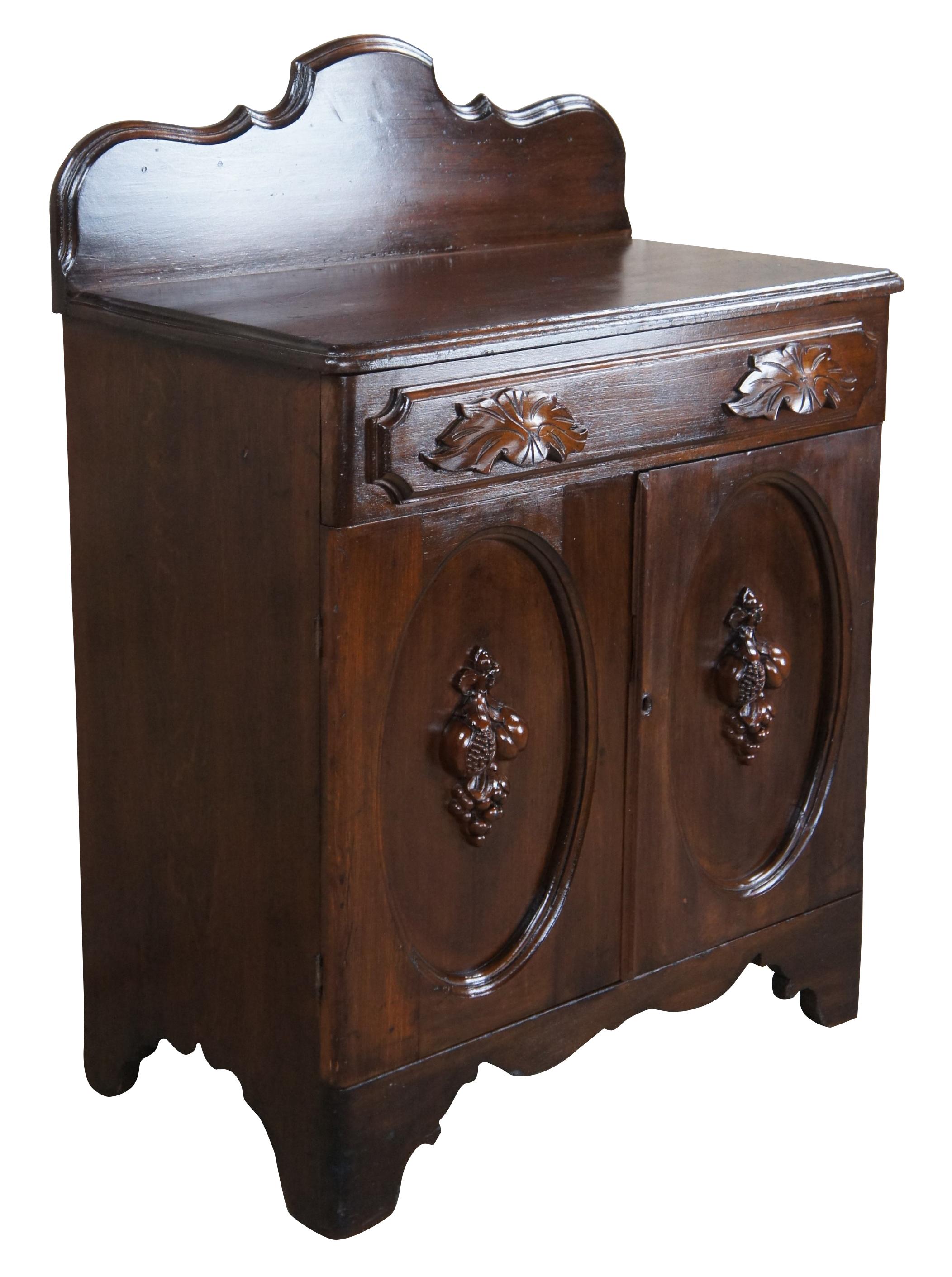 Antique Victorian parlor wash stand cabinet or side table / nightstand. Made of walnut featuring serpentine backsplash with upper drawer and lower cabinet and carved high relief fruit nut & berry design.

Measures: 26.5