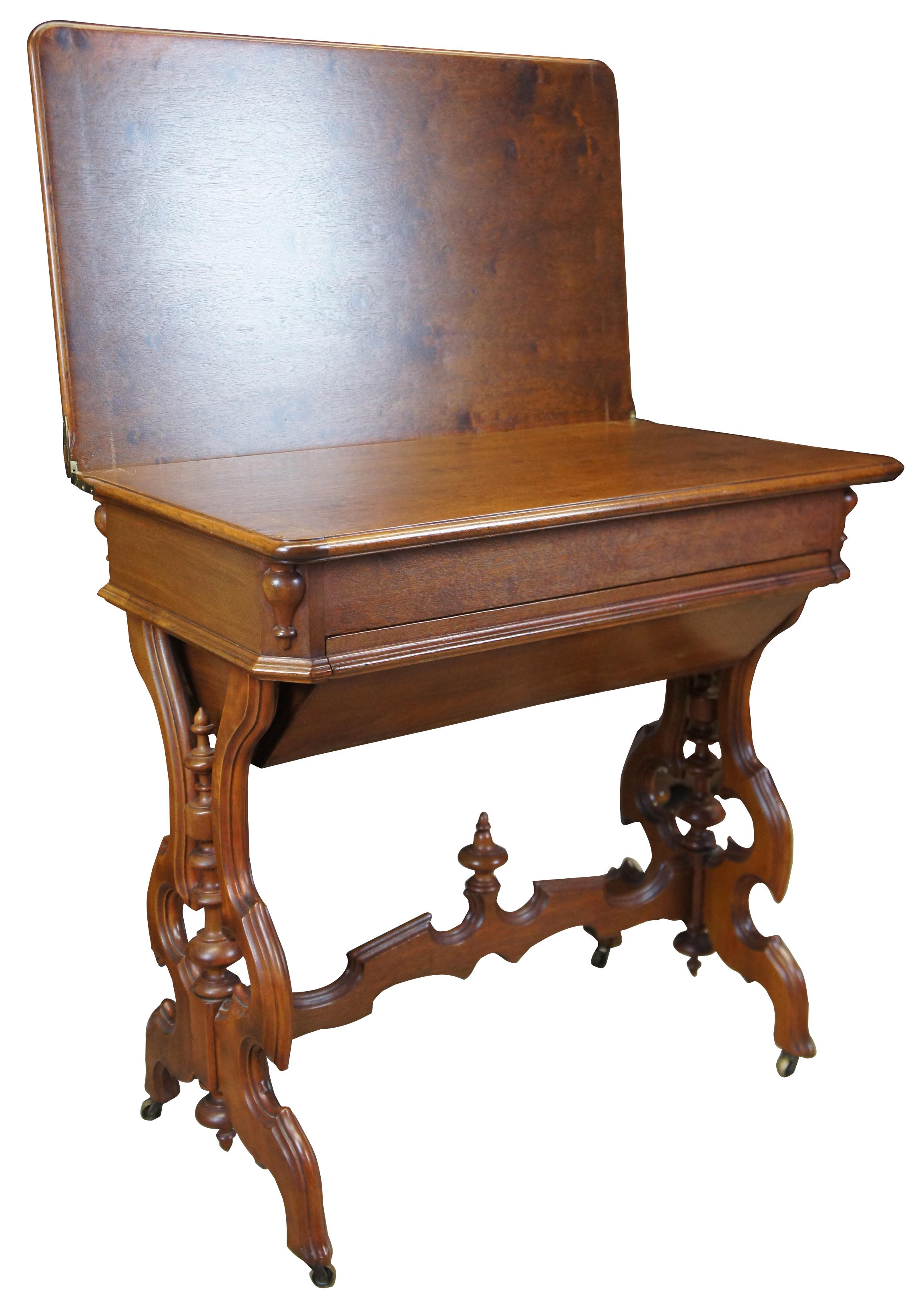 Walnut parlor table, circa 1880s. A unique dual functioning piece that can be used as a swivel top game table or sewing cabinet. Features a compartment for storage beneath the table top as well as a large dovetailed troth drawer. Intricately