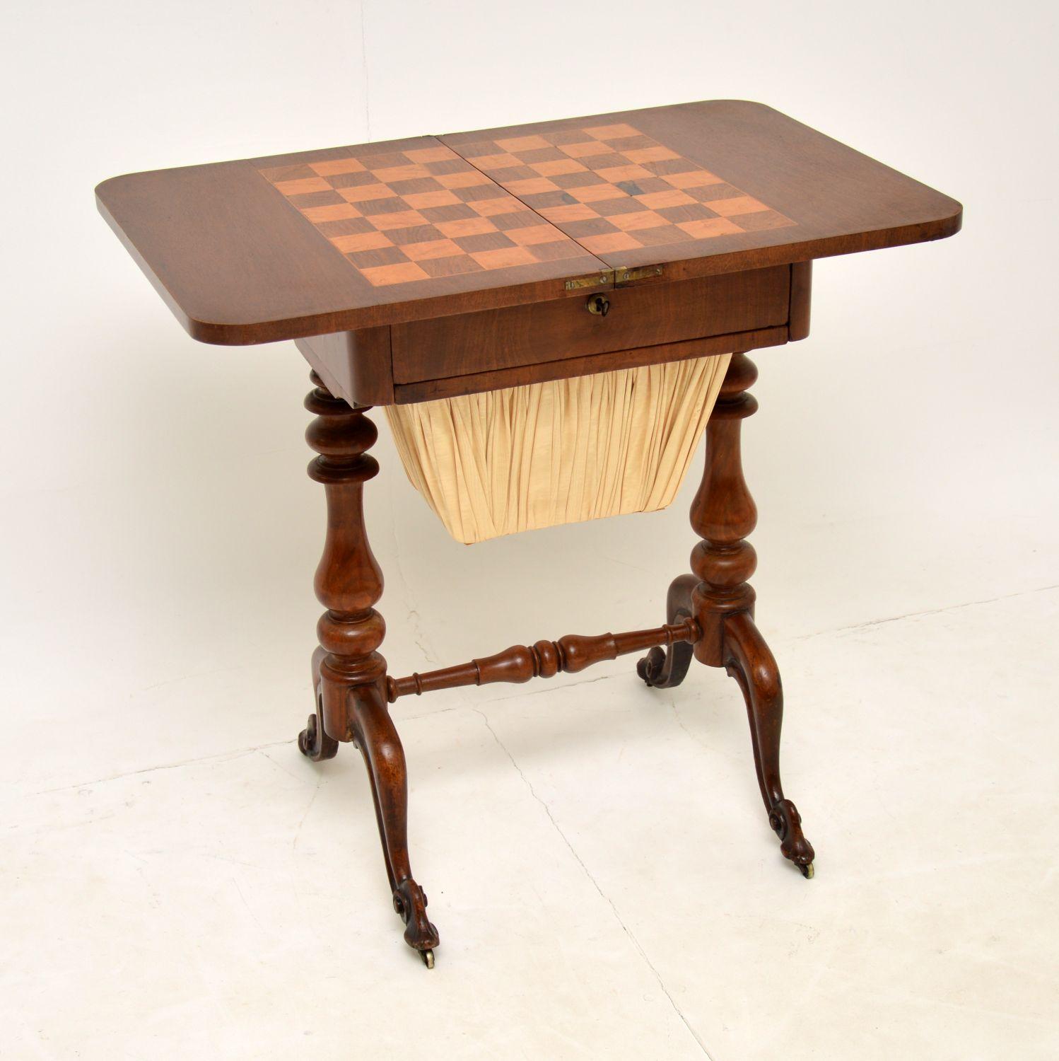 A lovely antique Victorian games table in walnut. This was made in England and dates from the 1850-1870 period.

It is very refined and of excellent quality. The top rotates and unfolds to reveal a built in chess board made of inlaid wood and