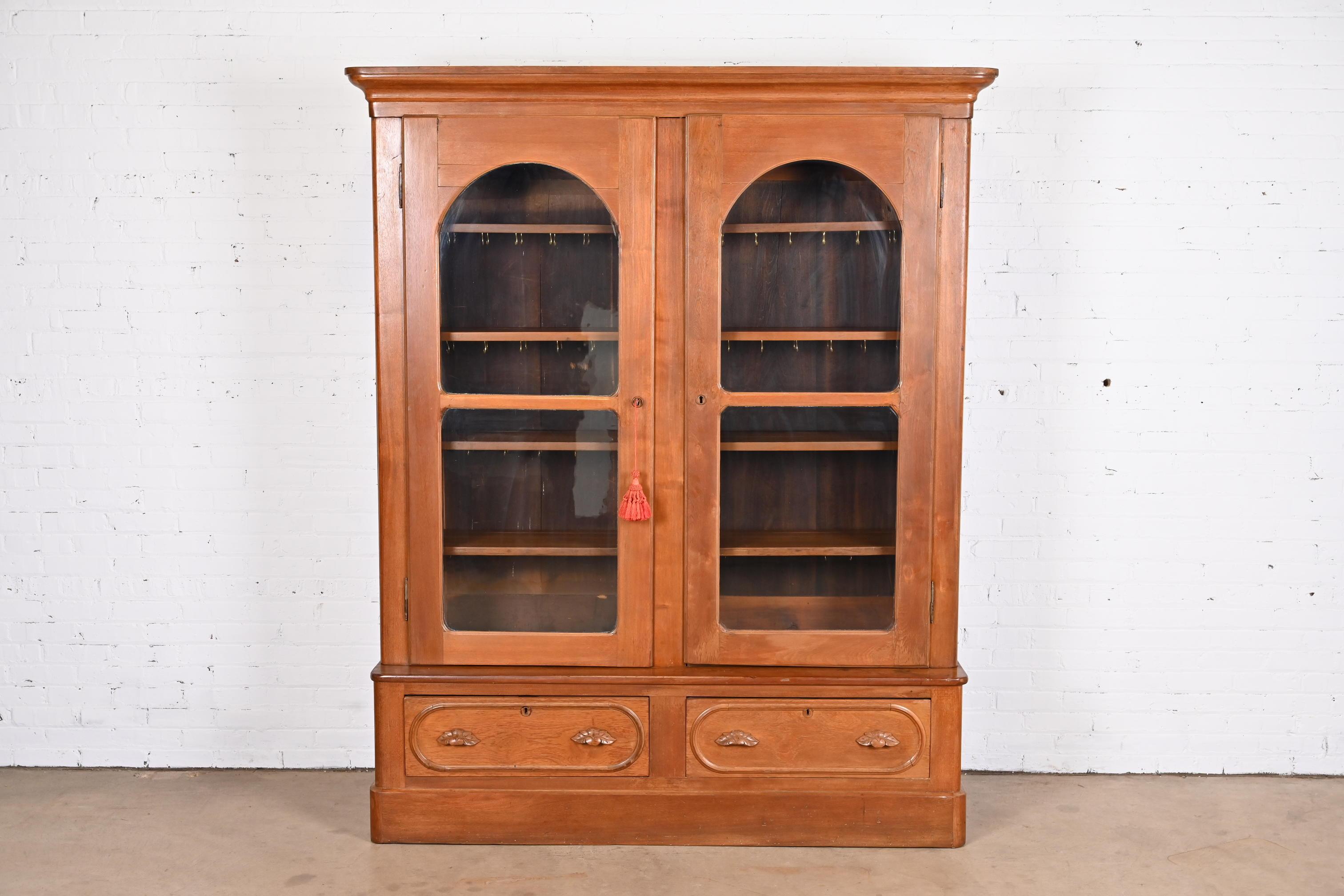 A beautiful antique Victorian knockdown double bookcase cabinet

USA, Circa 1880s

Carved solid walnut, with arched glass front doors.

Measures: 69