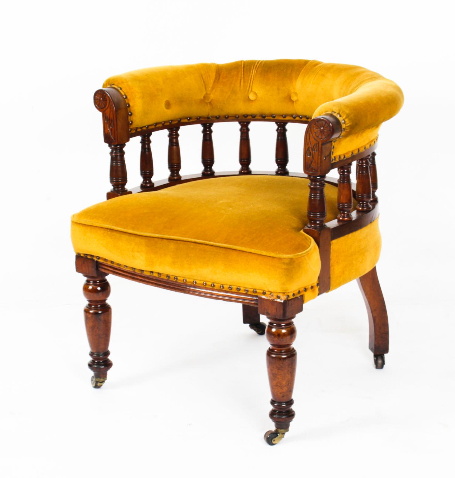 An elegant Victorian walnut and gold velvet upholstered desk chair circa 1880 in date.
 
This comfortable chair features a padded crest shaped back-rail on a turned spindle gallery with an overstuffed seat on further turned legs with brass and