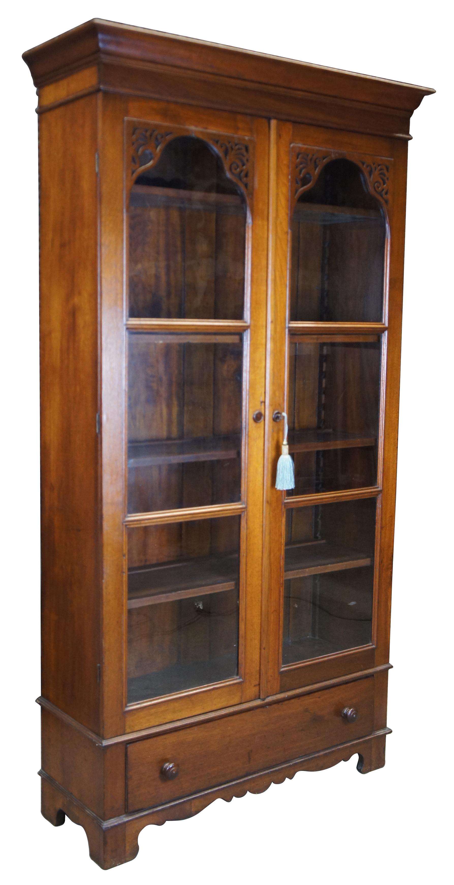 Victorian china cabinet or library bookcase, circa 1870s. Made from walnut with carved fretwork glass doors and lower drawer. The cabinet opens to four adjustable shelves and can be locked with key.
 