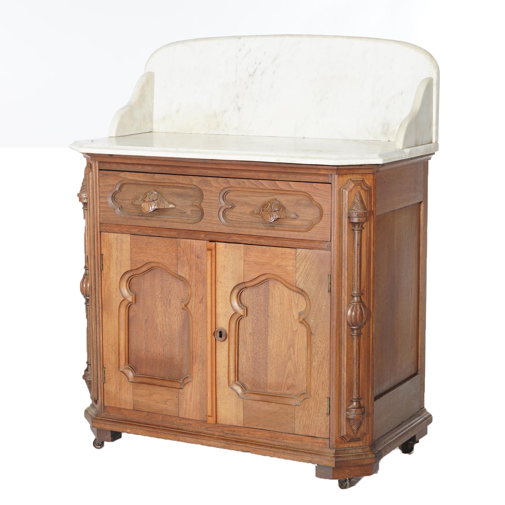 An antique Victorian commode offers beveled marble top and backsplash over walnut case having upper frieze drawer over double door blind cabinet with recessed arch panels, c1880

Measures - 41
