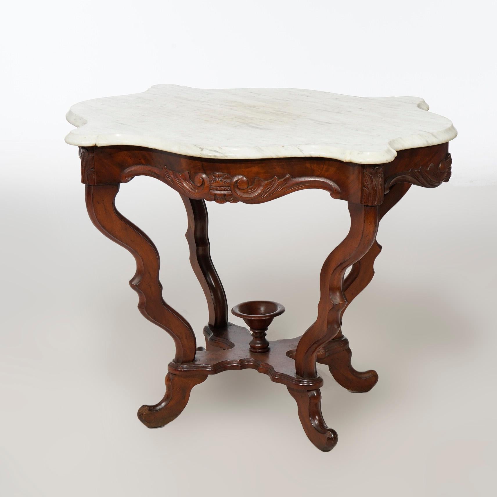 An antique Victorian parlor table offers shaped and beveled marble turtle top over walnut base having scroll form legs and central chalice form finial, c1890

Measures- 28.25''H x 35''W x 25.5''D
