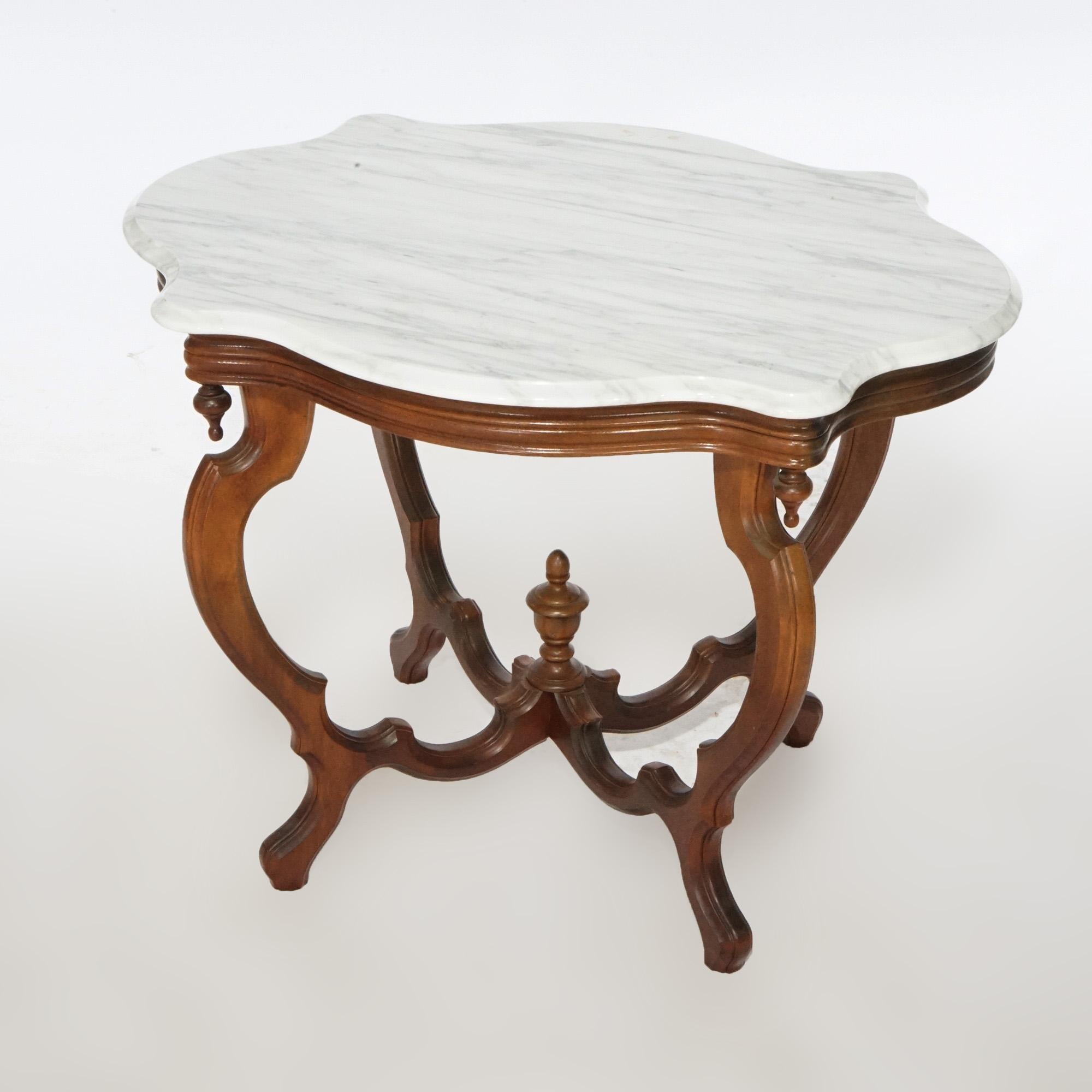An antique Victorian parlor table offers shaped and beveled marble turtle top over walnut base having reeded skirt with drop finials and raised on scroll from cabriole legs with central urn-form finial, c1890.

Measures- 28.25''H x 36''W x 28''D.