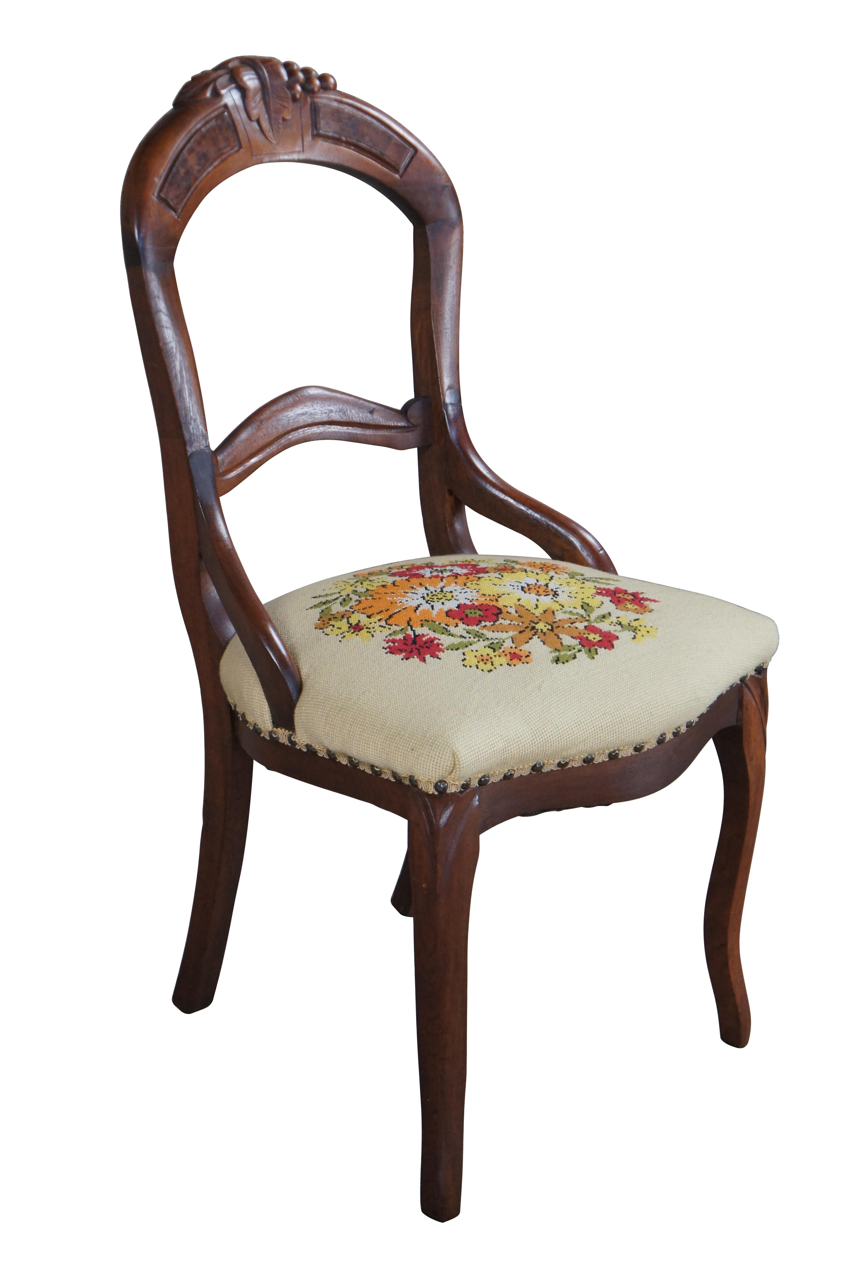 Silla de salón o de comedor victoriana antigua.  De madera de nogal, con respaldo en forma de globo con corona de hojas y bayas y asiento de punto de aguja floral con remate de clavos.

Dimensiones:
18,5