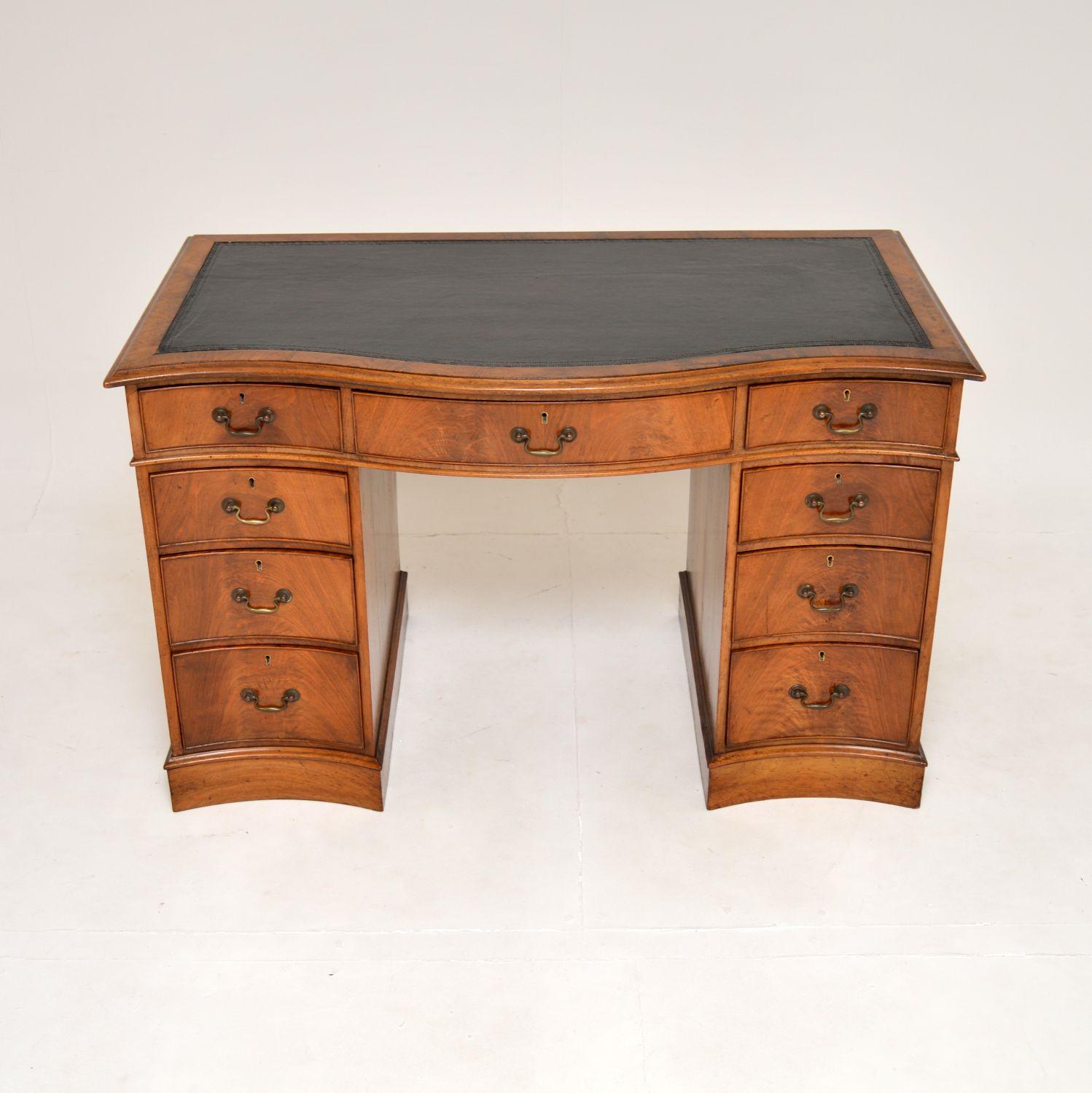 A superb antique Victorian walnut pedestal desk. This was made in England, it dates from around the 1880-1900 period.

It is of outstanding quality, it is extremely well made and sturdy. This has a serpentine shaped front, with high quality brass